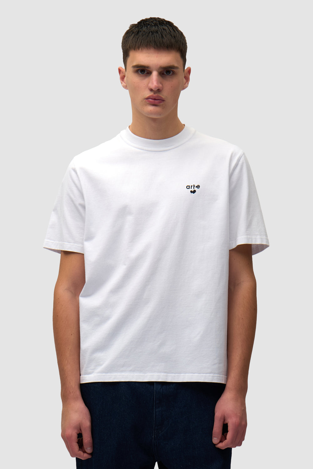 T-shirt blanc avec logo en forme de cœur porté par un mannequin, vue de face à mi-corps