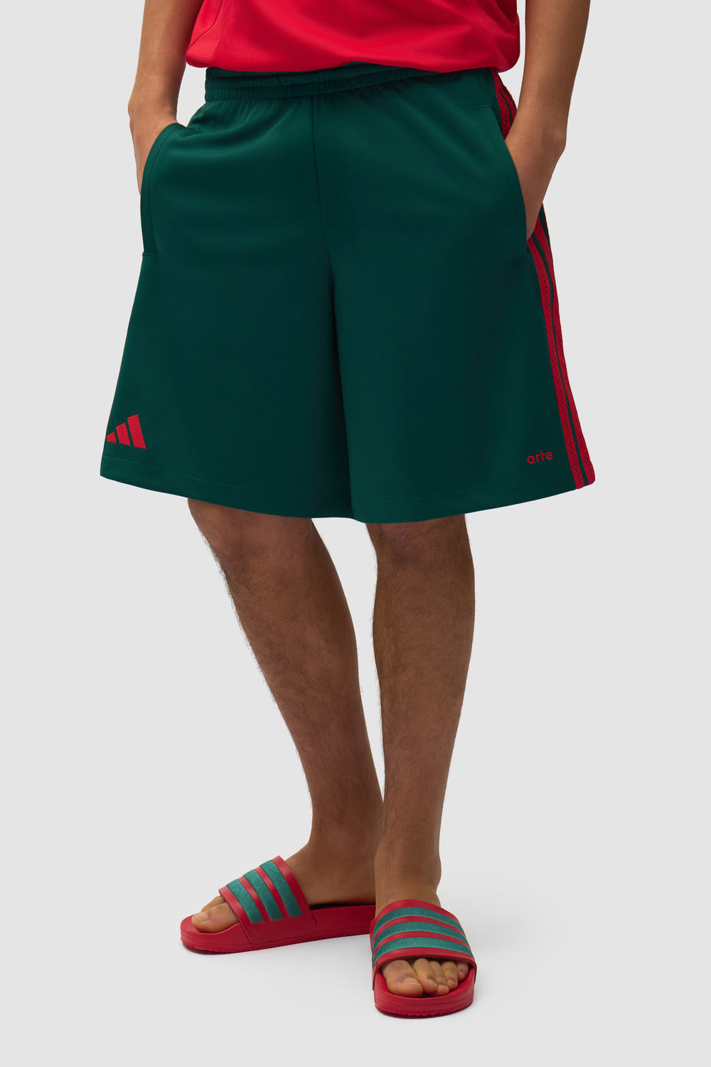 Arte pour adidas Short vert universitaire porté par un mannequin, vue de face en demi-corps