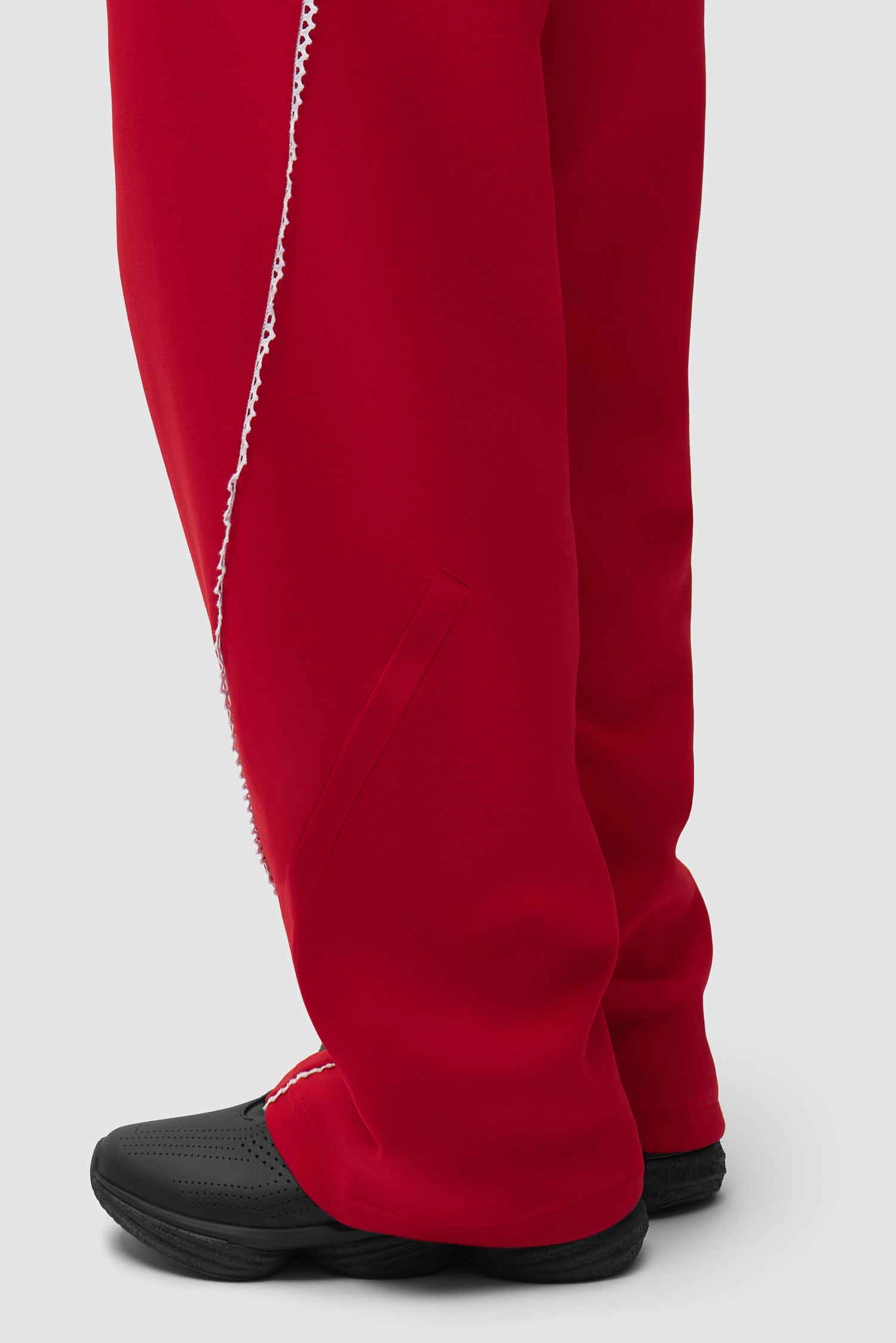 Vue détaillée du pantalon Arte pour adidas Z.N.E. en Better Scarlet/White, avec logo au bas.