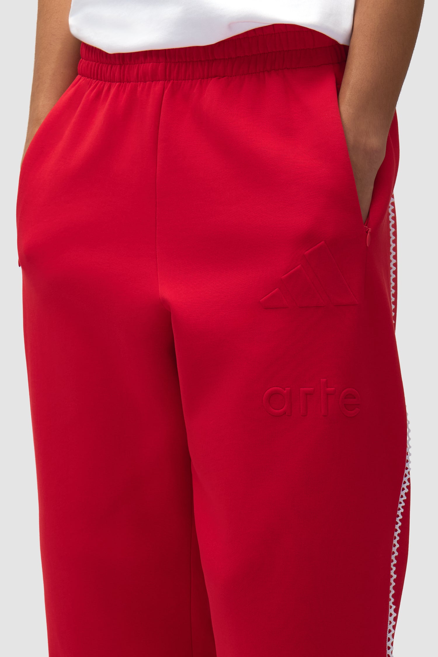 Vue détaillée du pantalon Arte pour adidas Z.N.E. en Better Scarlet/White, avec logo sur le devant.