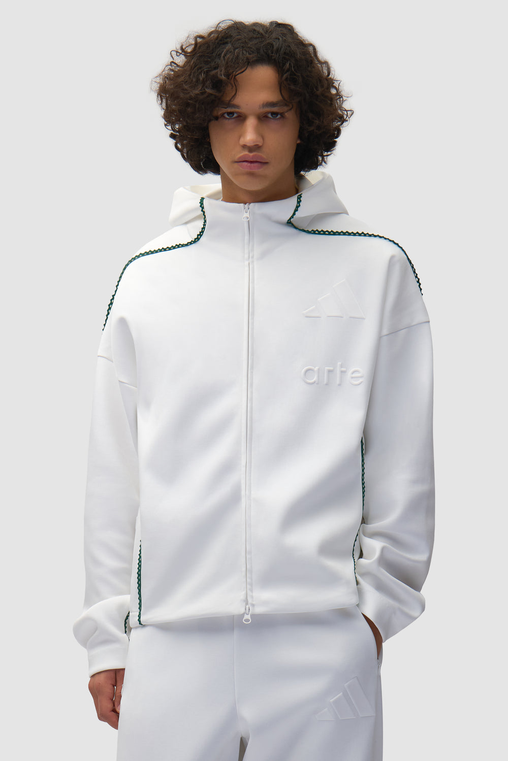Veste Arte pour adidas Z.N.E. en blanc/Better Scarlet portée par un mannequin, vue de face en demi-corps