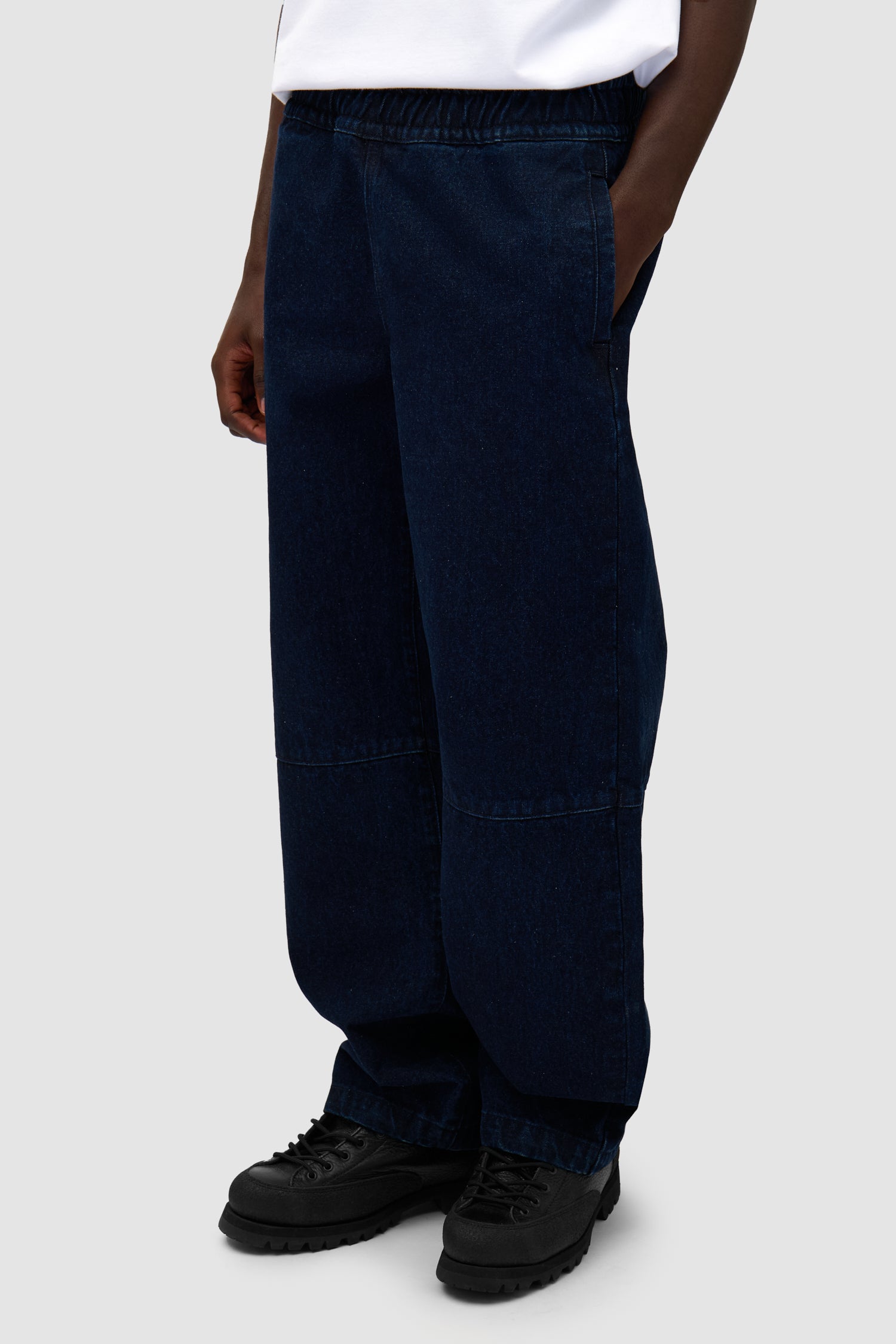 Denim Tech Pants in Navy worn by a model, half-body side view