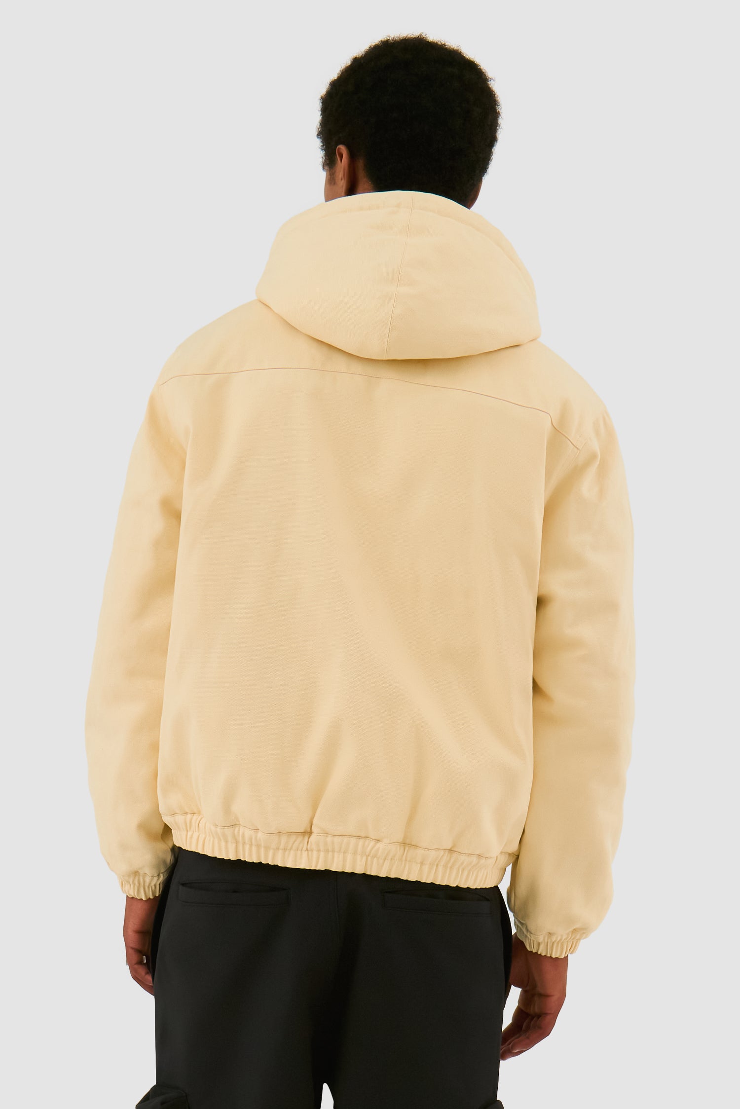 Reversible Hooded Jacket in Cream worn by a model, half-body back view