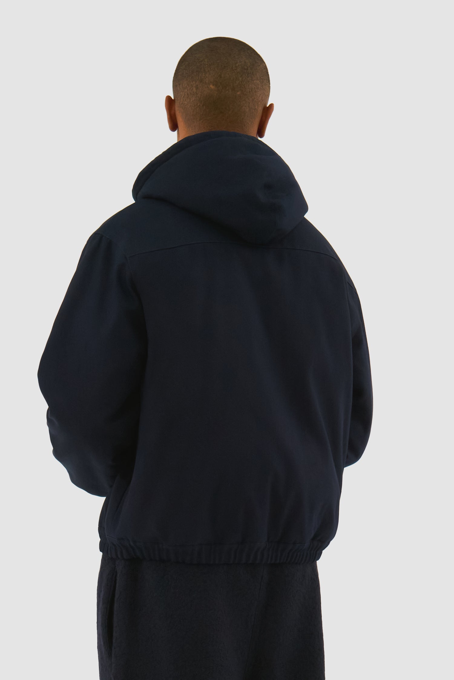 Reversible Hooded Jacket in Navy worn by a model, half-body back view