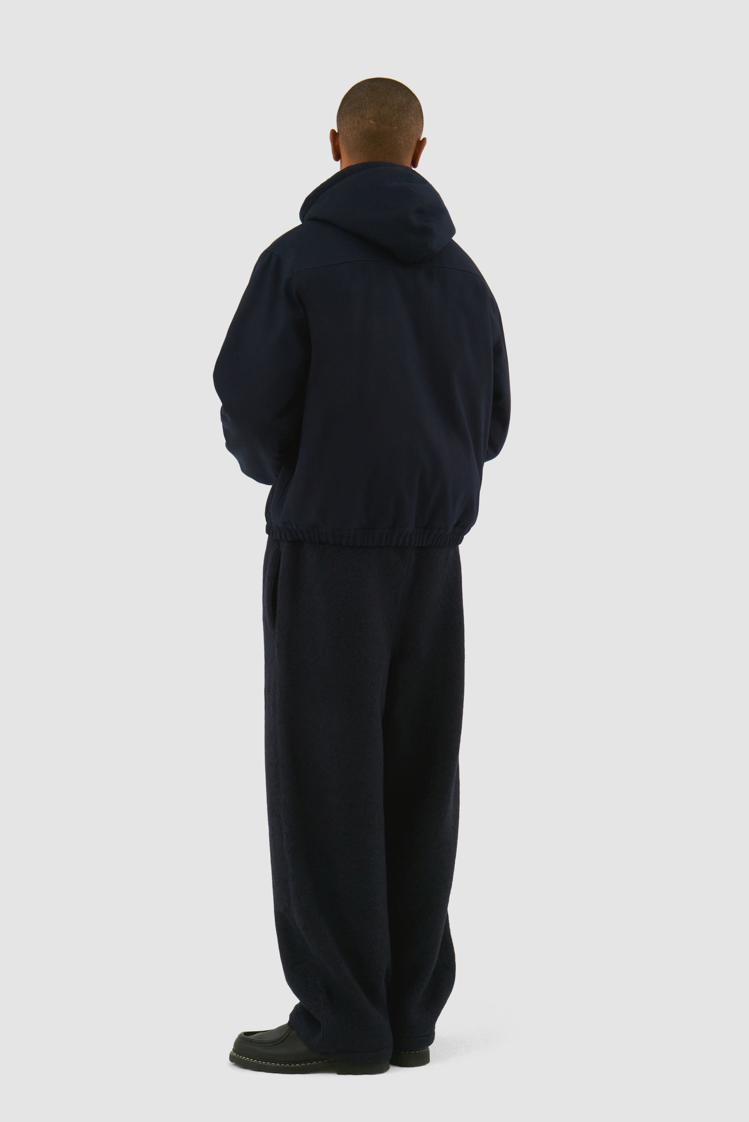 Reversible Hooded Jacket in Navy worn by a model, full-body back view