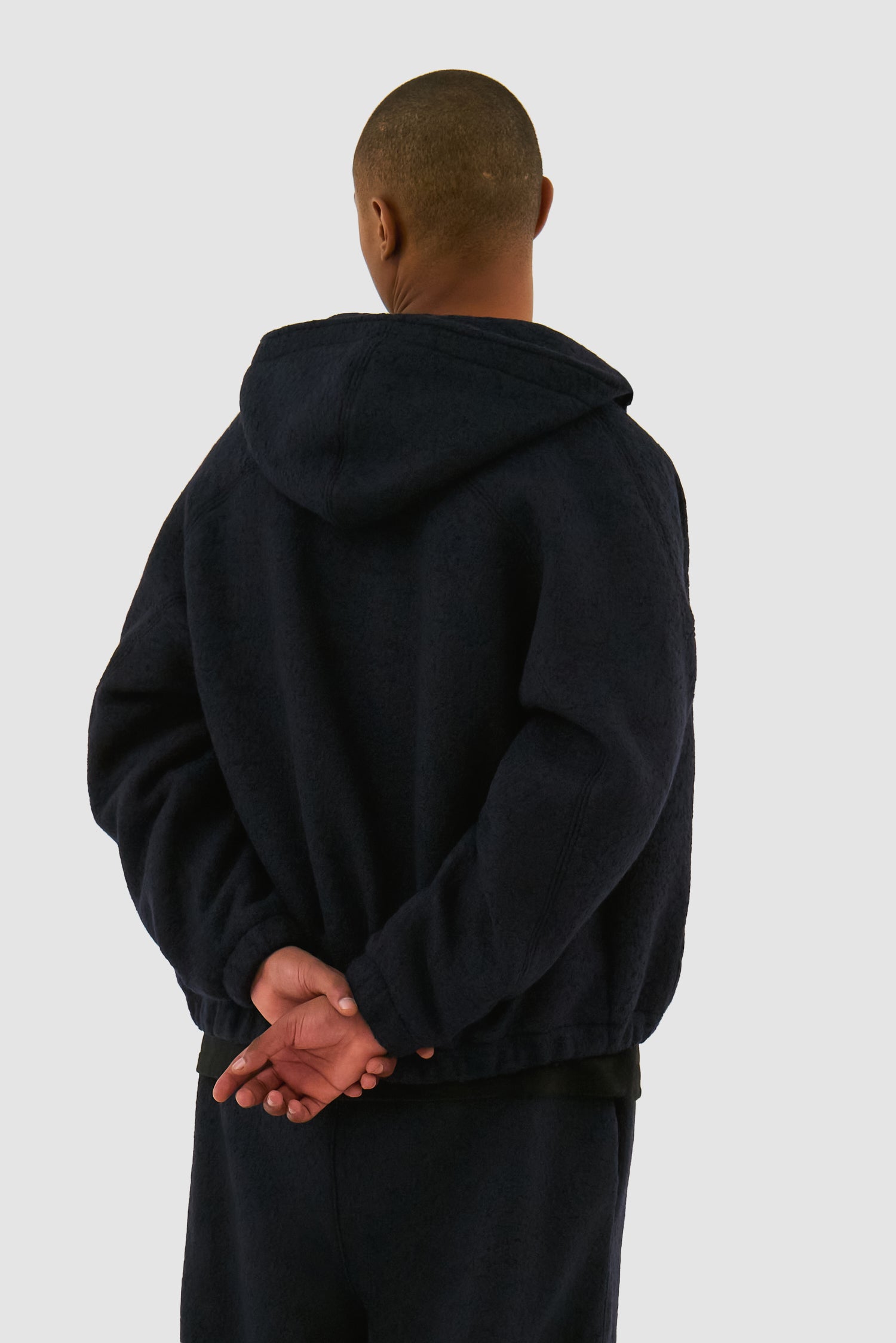 Wool Hooded Jacket in Navy worn by a model, half-body back view