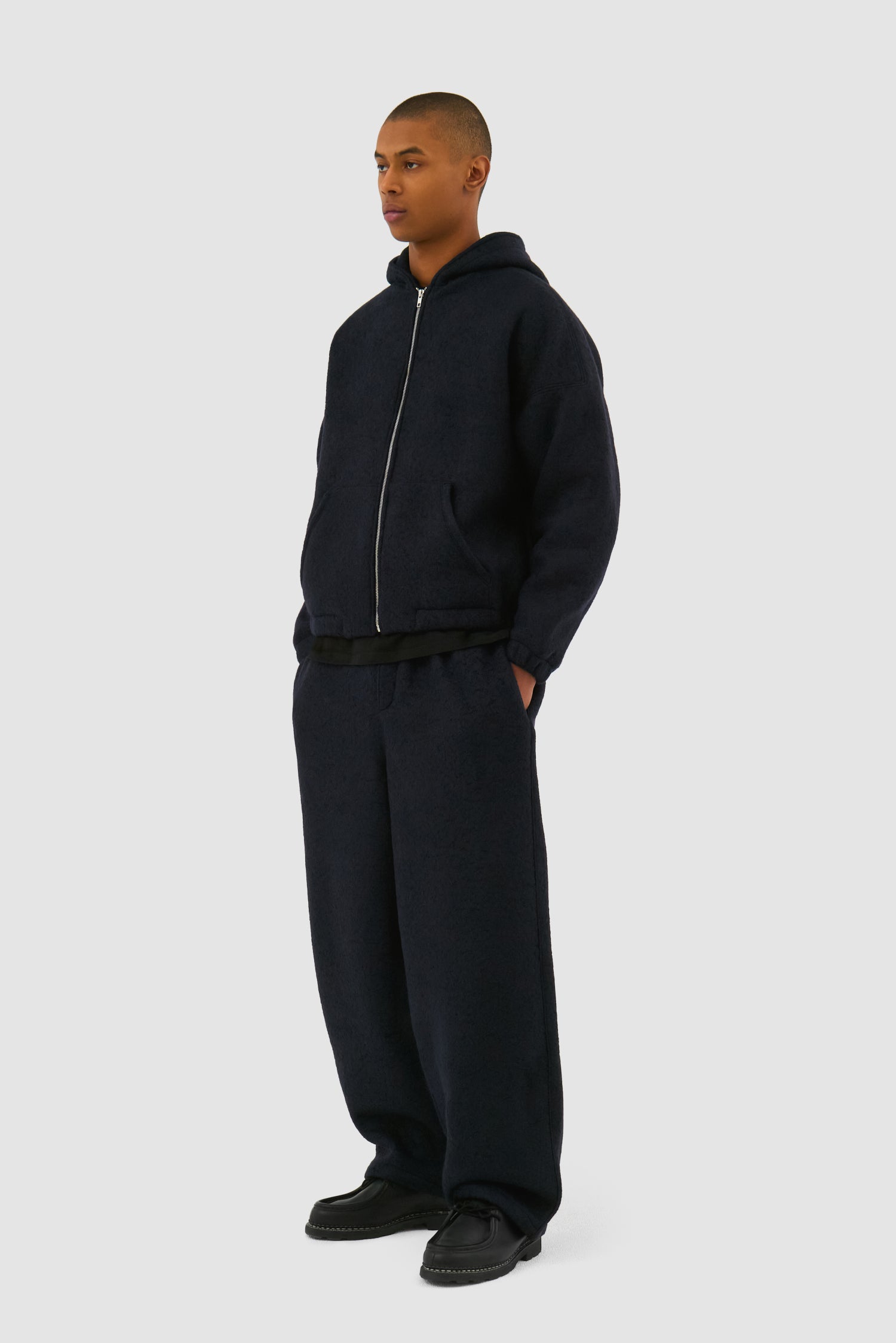 Wool Hooded Jacket in Navy worn by a model, full-body side view
