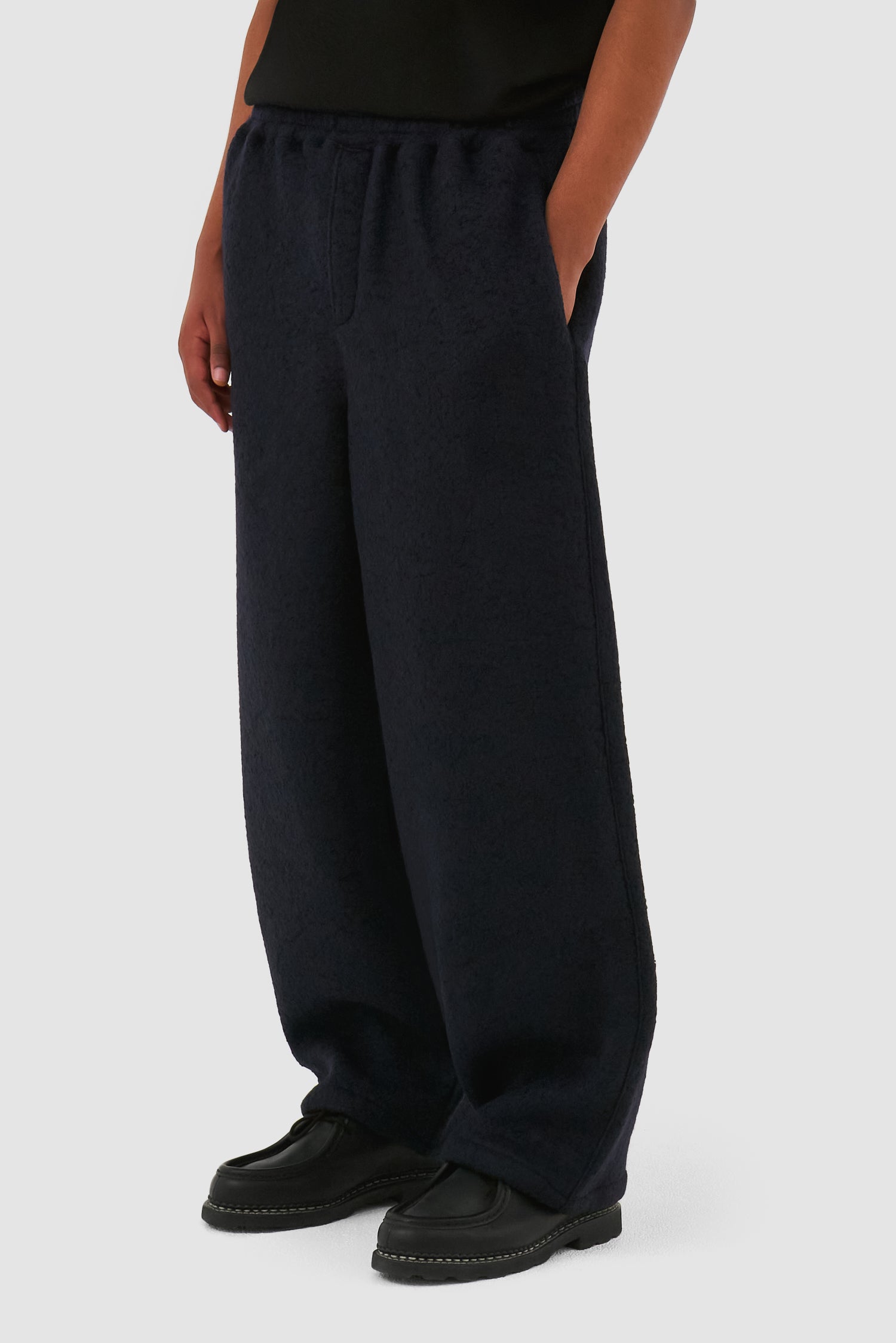 Boiled Wool Pants in Navy worn by a model, full-body back view