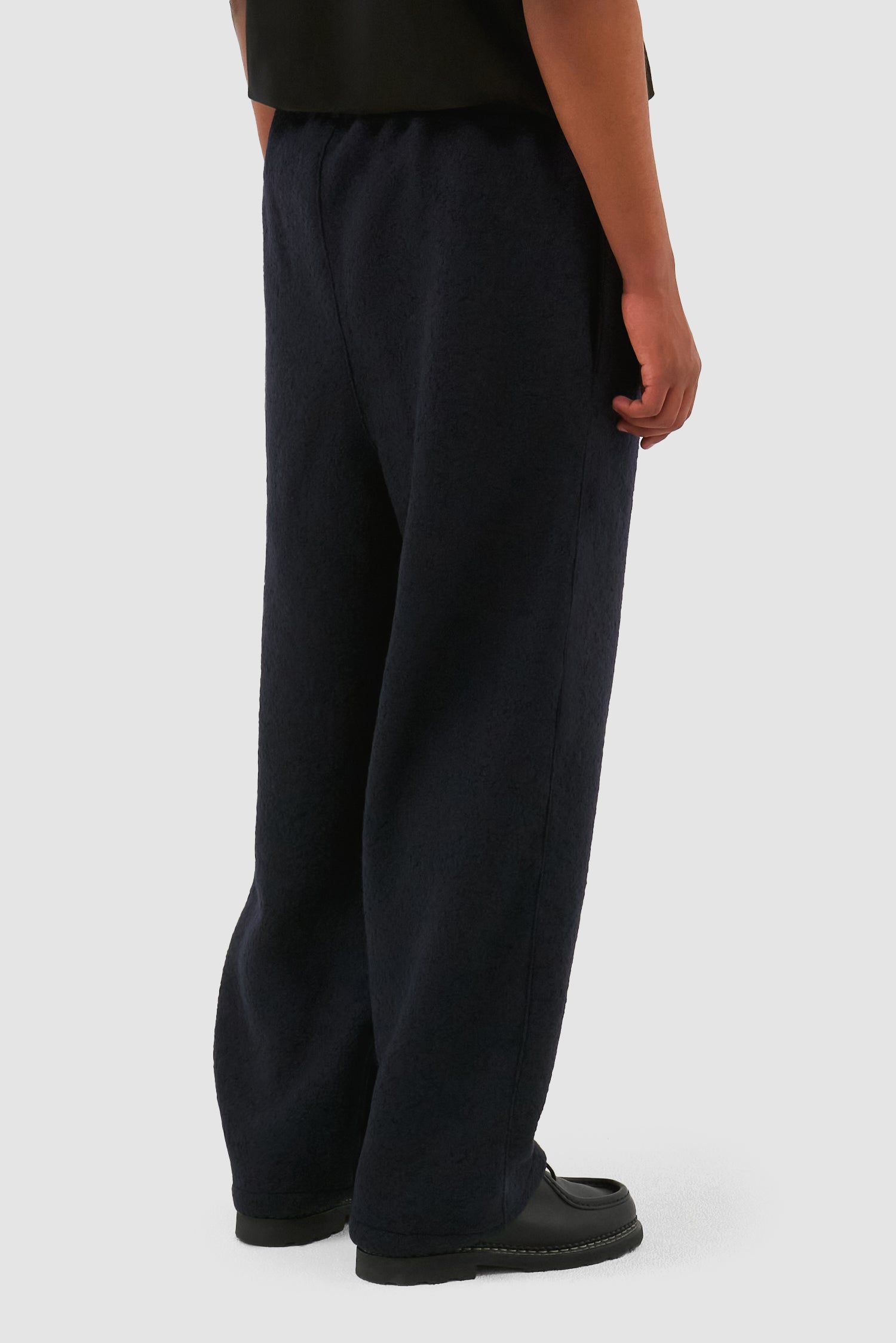 Boiled Wool Pants in Navy worn by a model, half-body side view