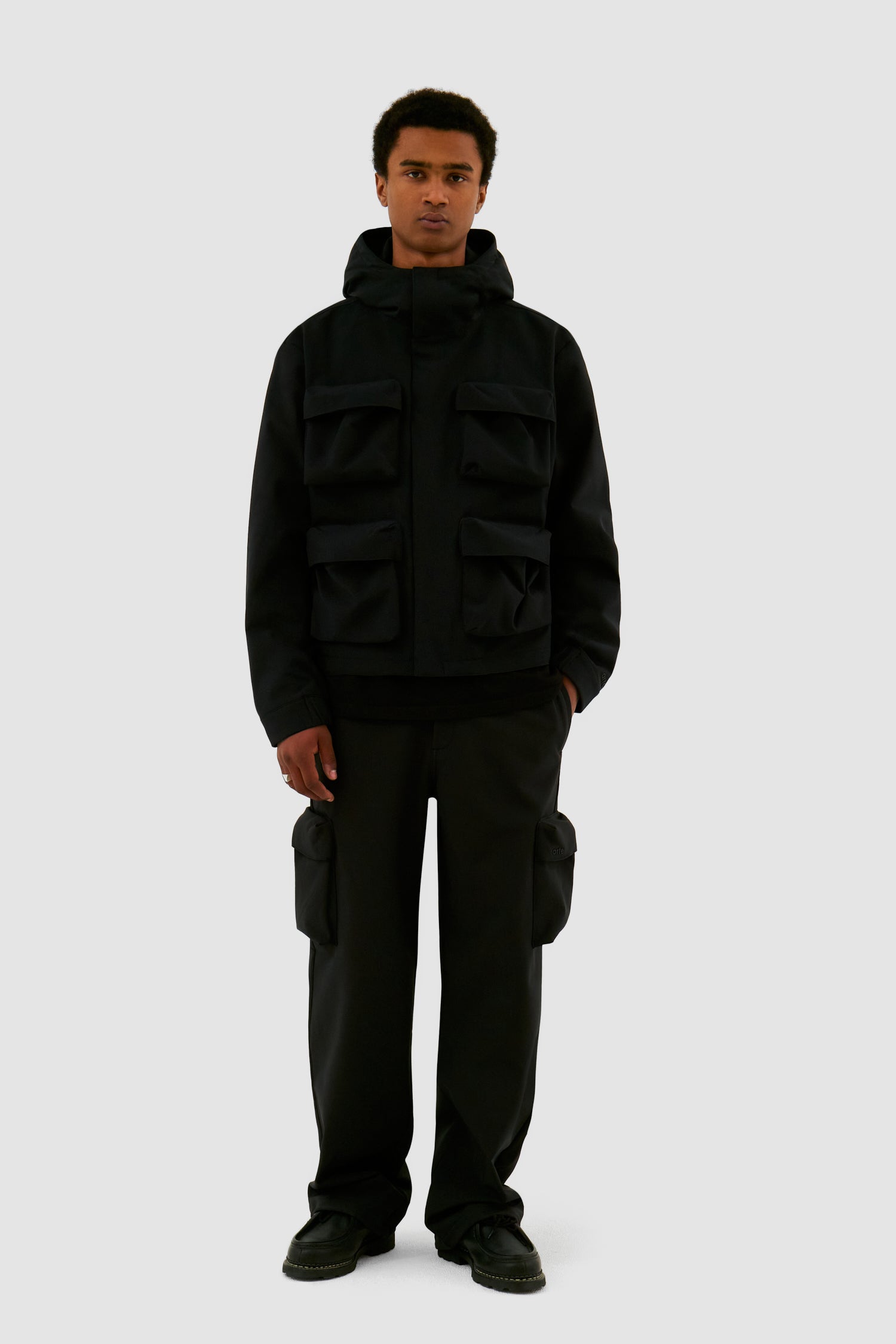 3D Pockets Hooded Nylon Jacket in Black worn by a model, full-body front view