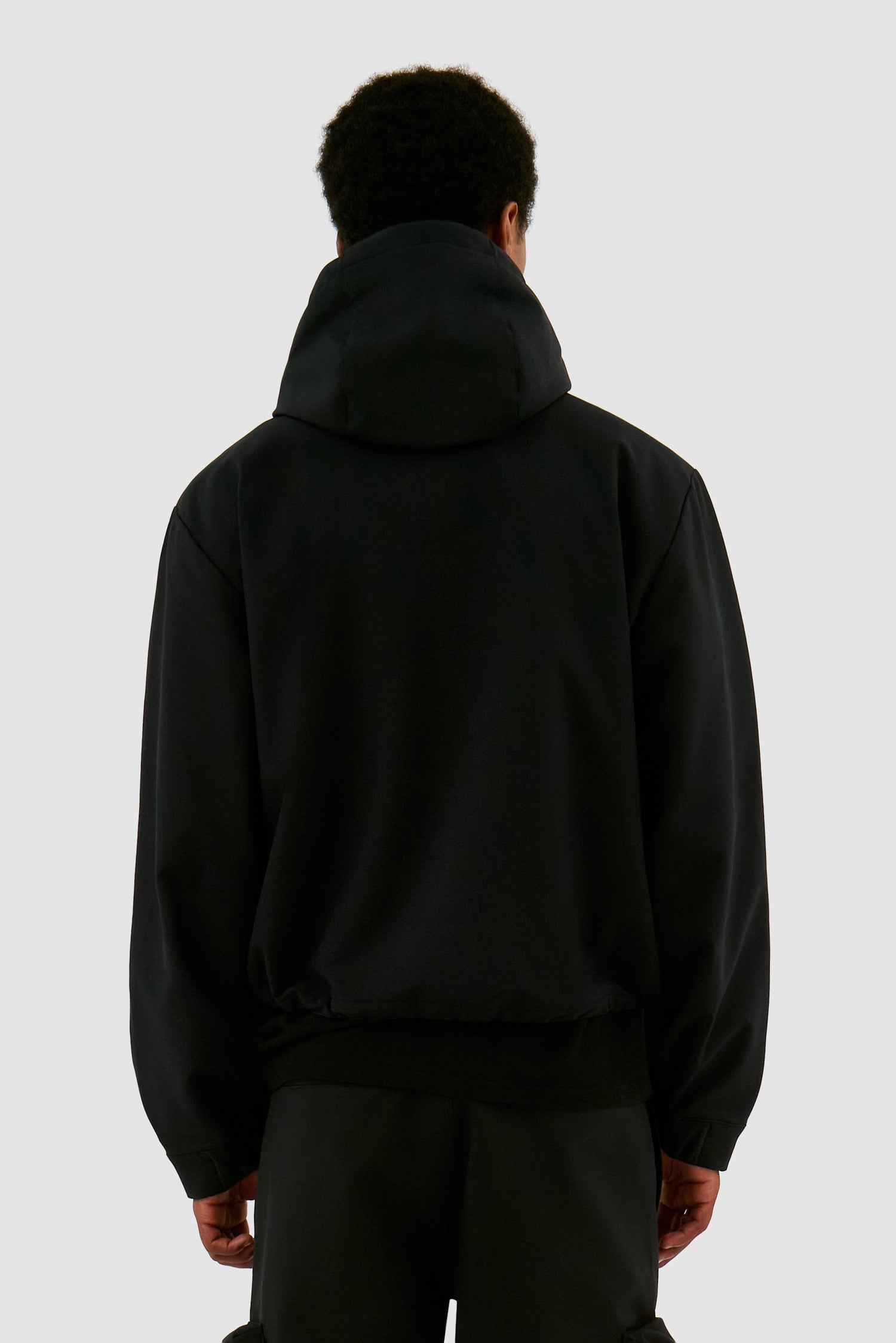 3D Pockets Hooded Nylon Jacket in Black worn by a model, half-body back view