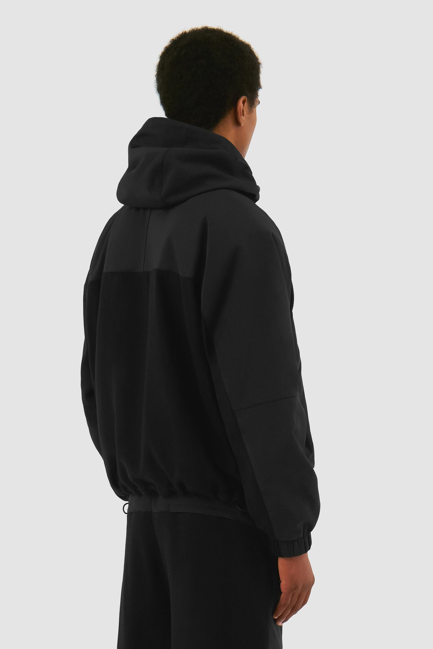 Wool Technical Jacket in Black worn by a model, half-body back view