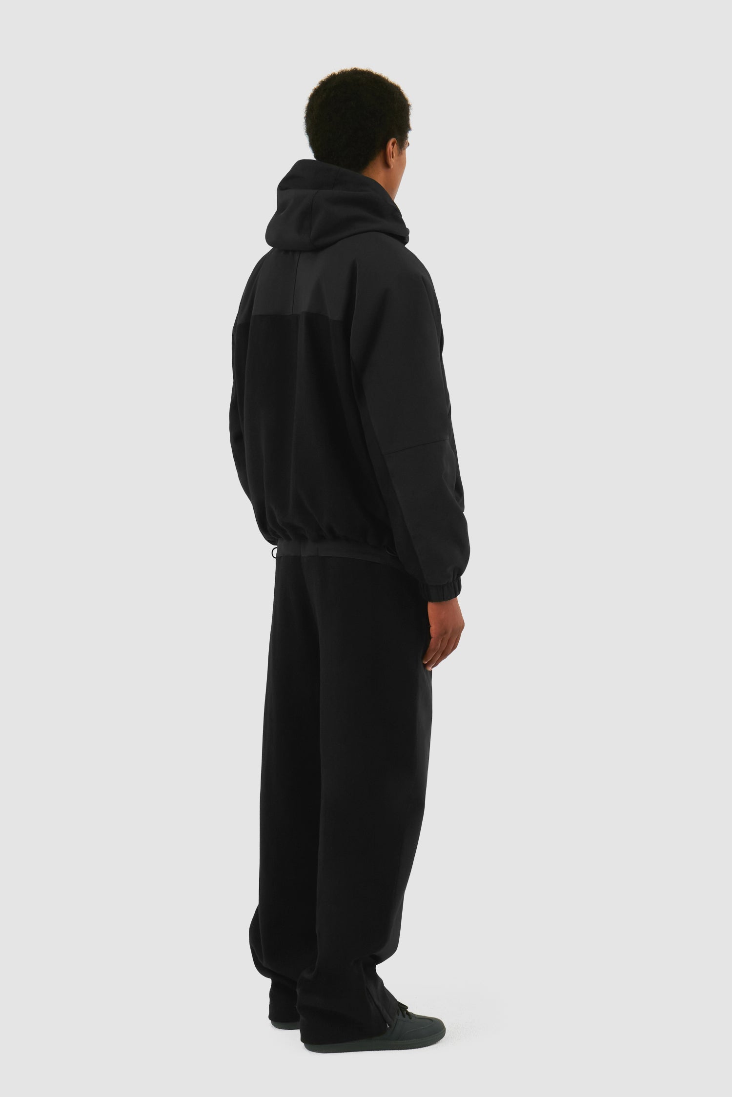 Wool Technical Jacket in Black worn by a model, full-body back view