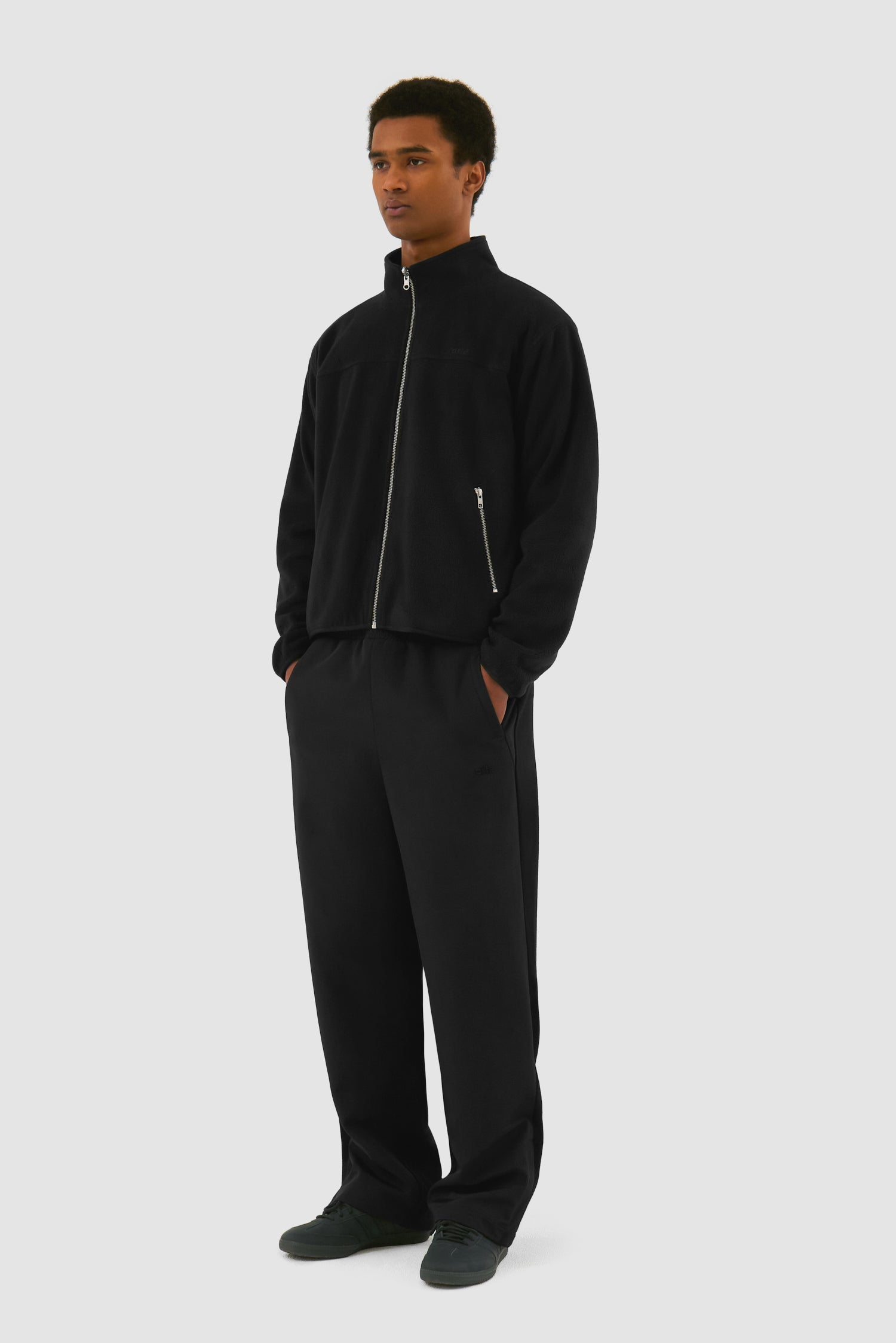 Wool Technical Jacket in Black worn by a model, full-body side view showing the inside layer