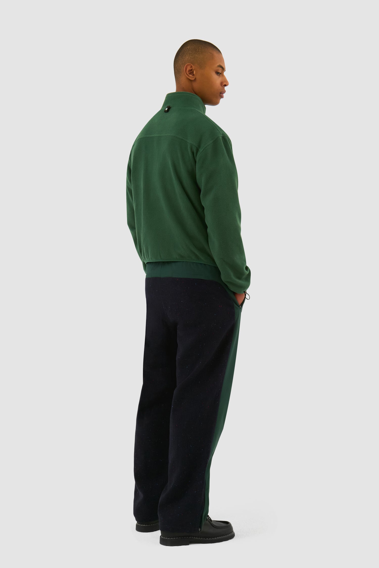 Wool Technical Jacket in Green worn by a model, full-body back view showing the inside layer