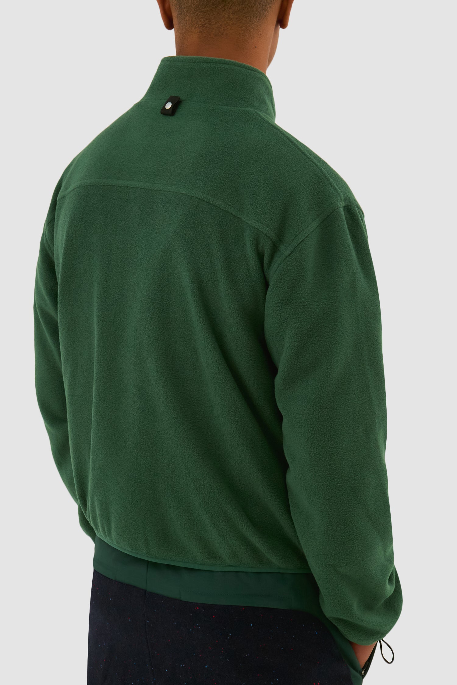 Wool Technical Jacket in Green worn by a model, half-body back view showing the inside layer
