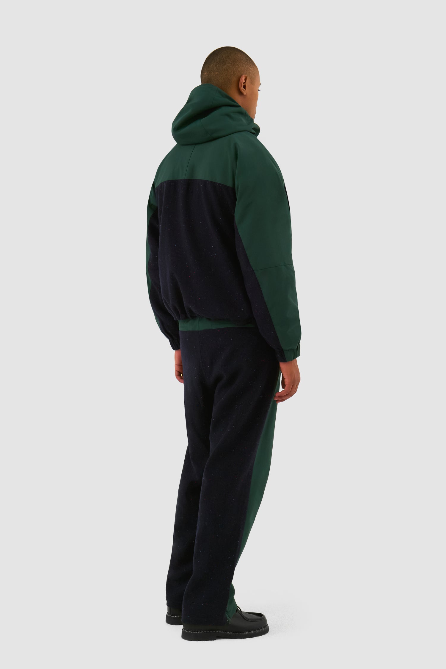 Wool Technical Pants in Green worn by a model, full-body side view