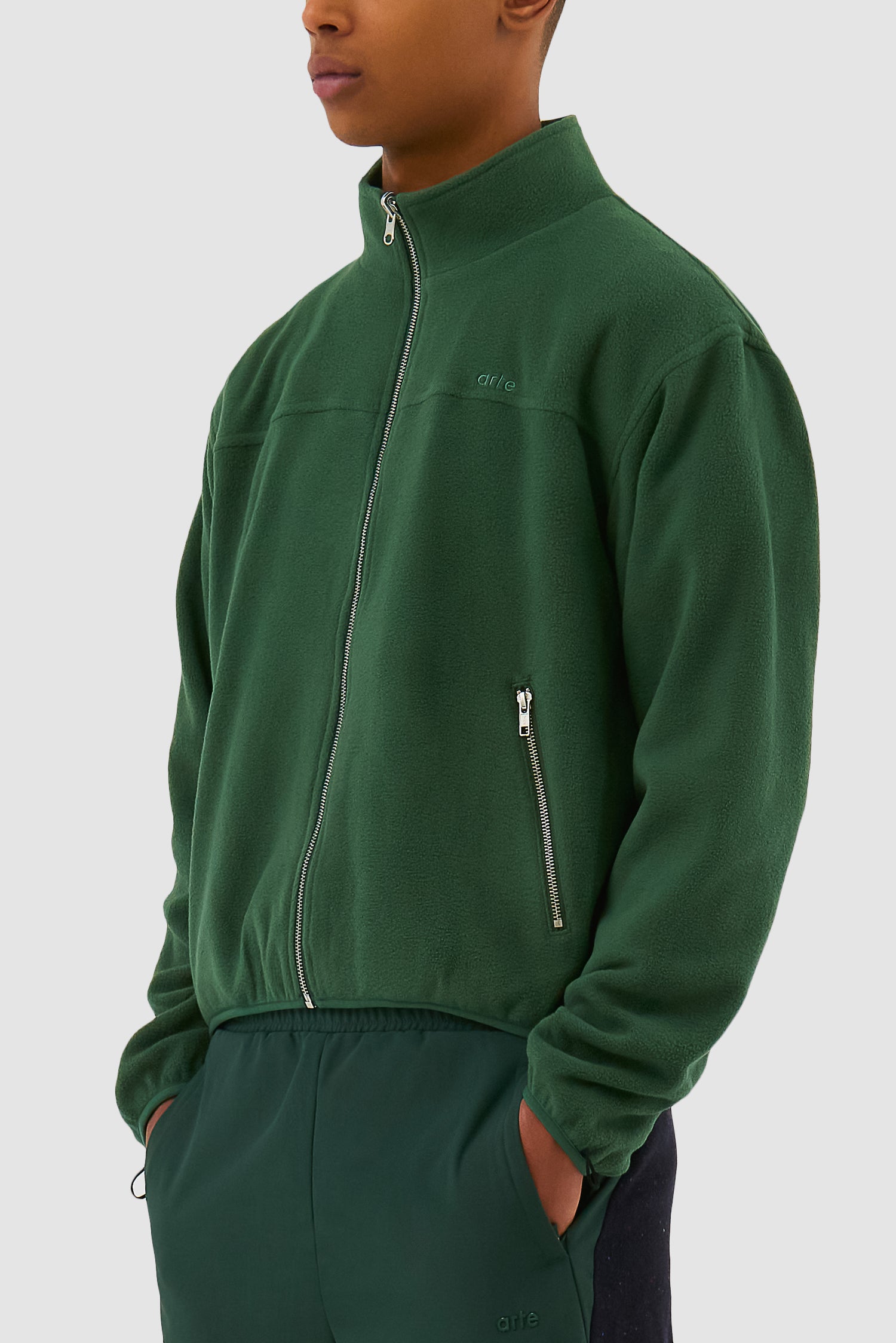 Wool Technical Jacket in Green worn by a model, half-body side view showing the inside layer