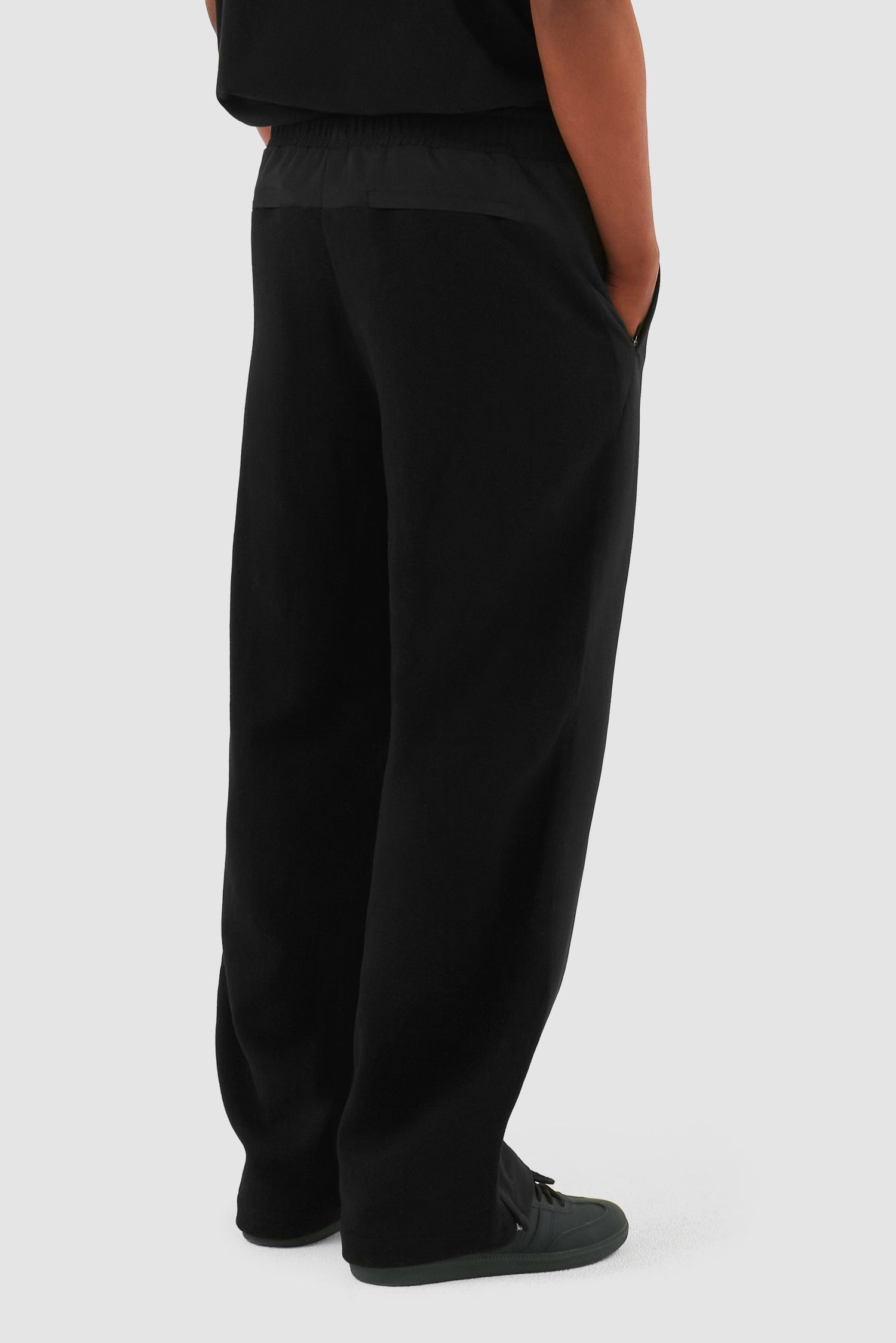 Wool Technical Pants in Black worn by a model, half-body side view