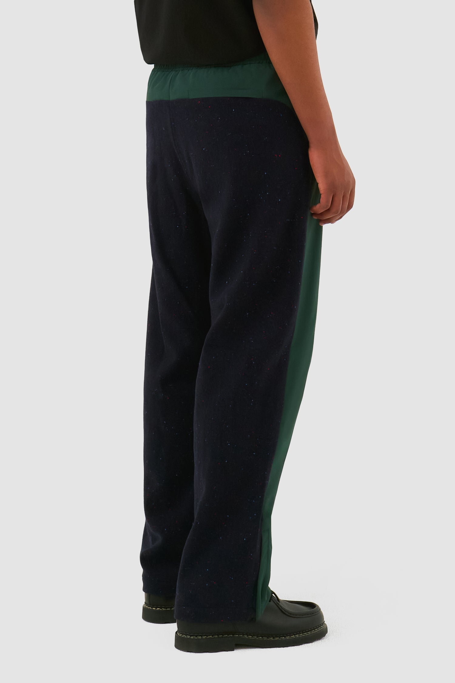 Wool Technical Pants in Green worn by a model, half-body side view
