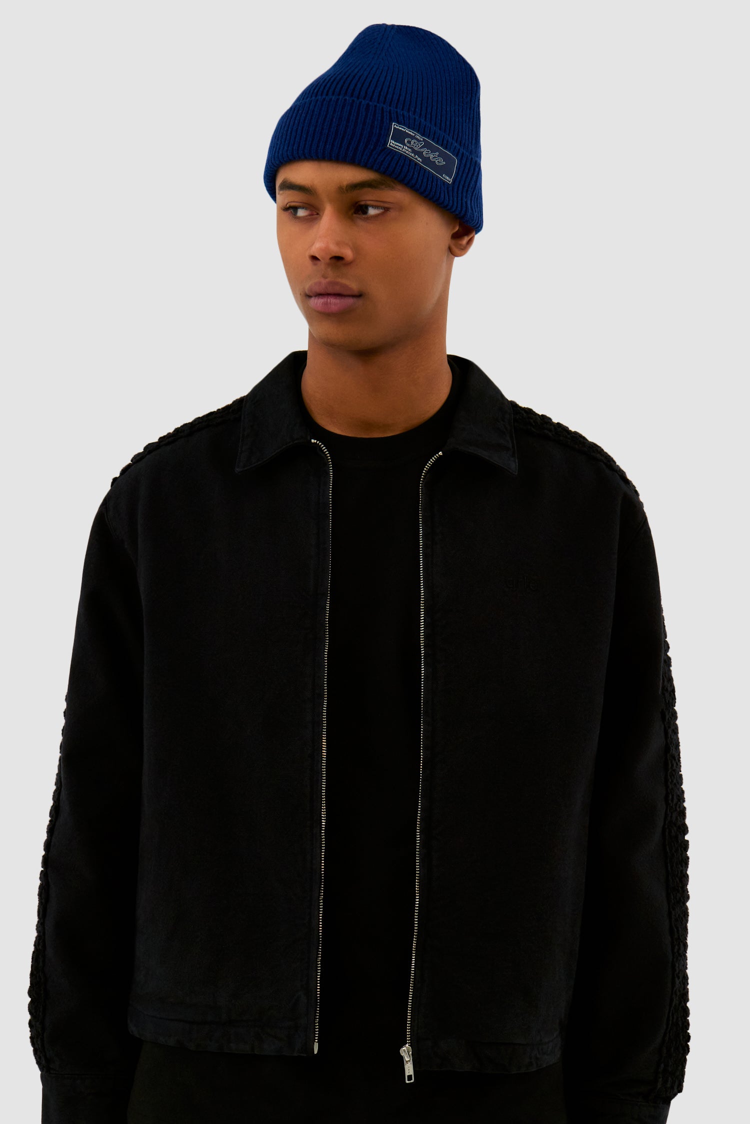 Woven Label Beanie in Navy worn by a model, half-body front view