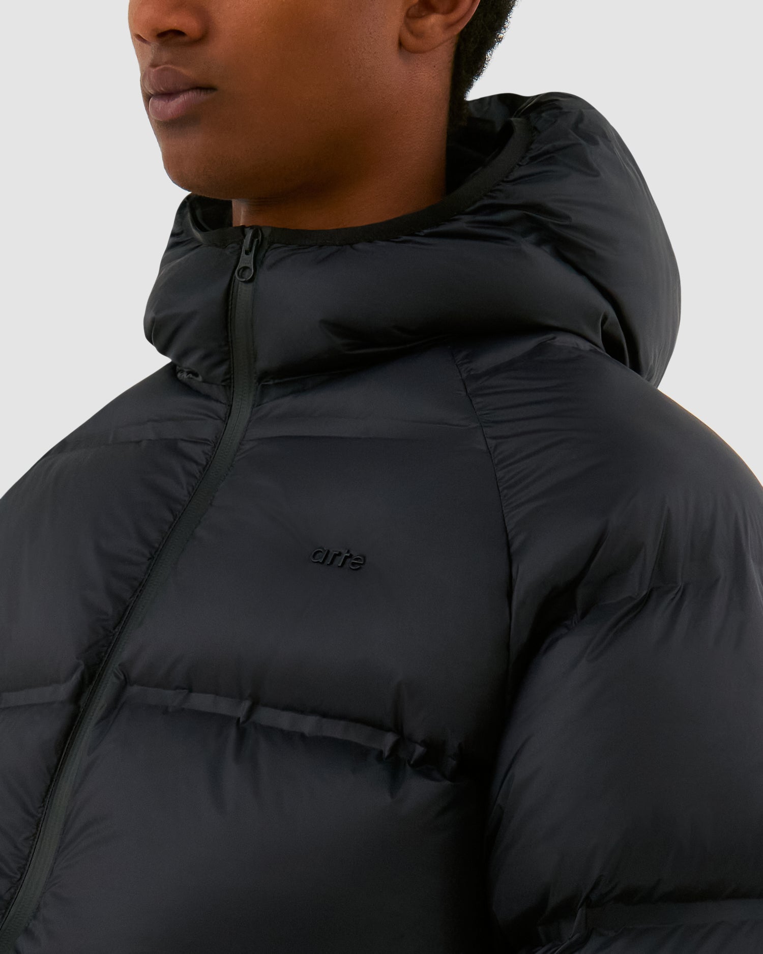 Crop Puffer Jacket in Black worn by a model, half-body detailed view
