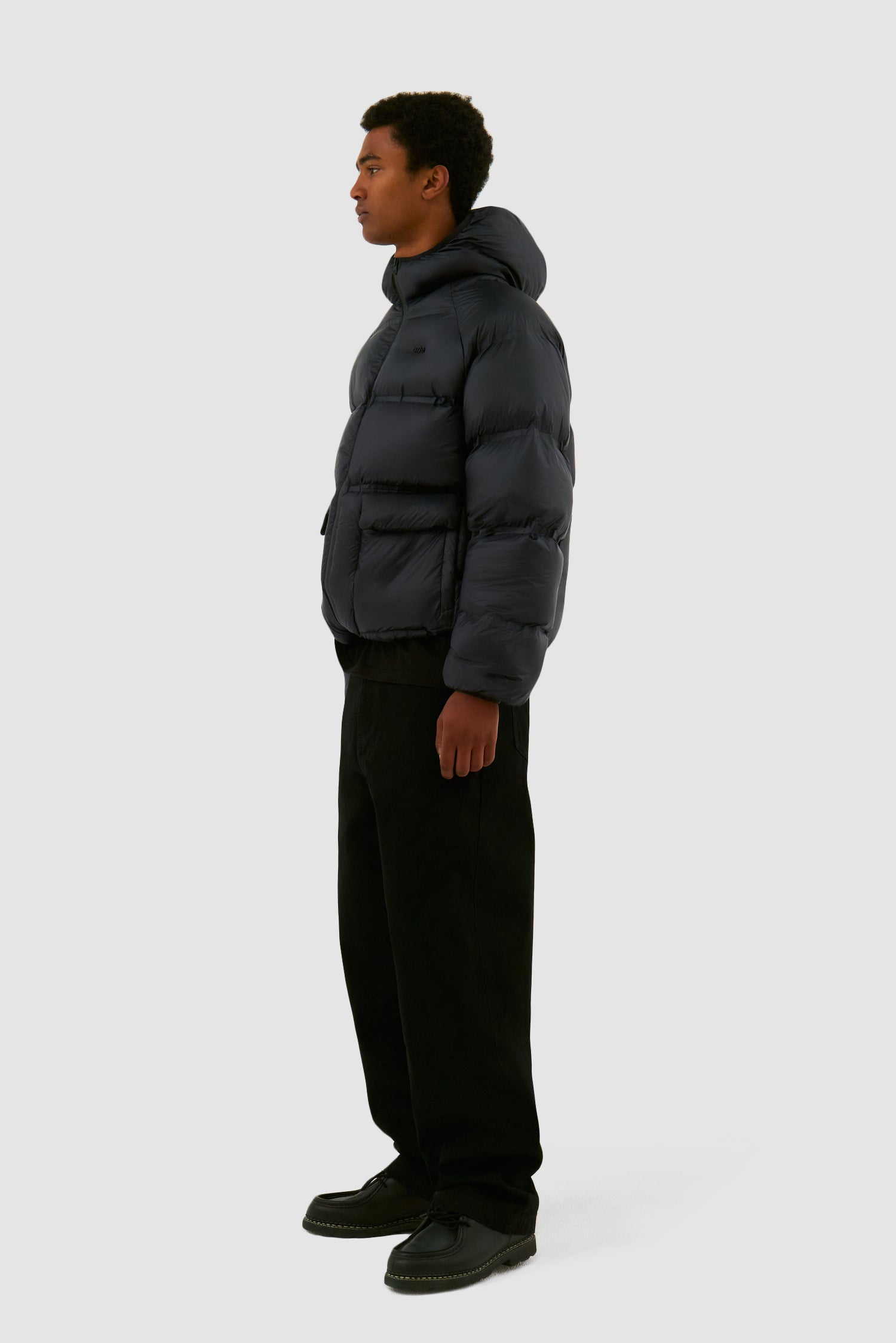 Crop Puffer Jacket in Black worn by a model, full-body side view