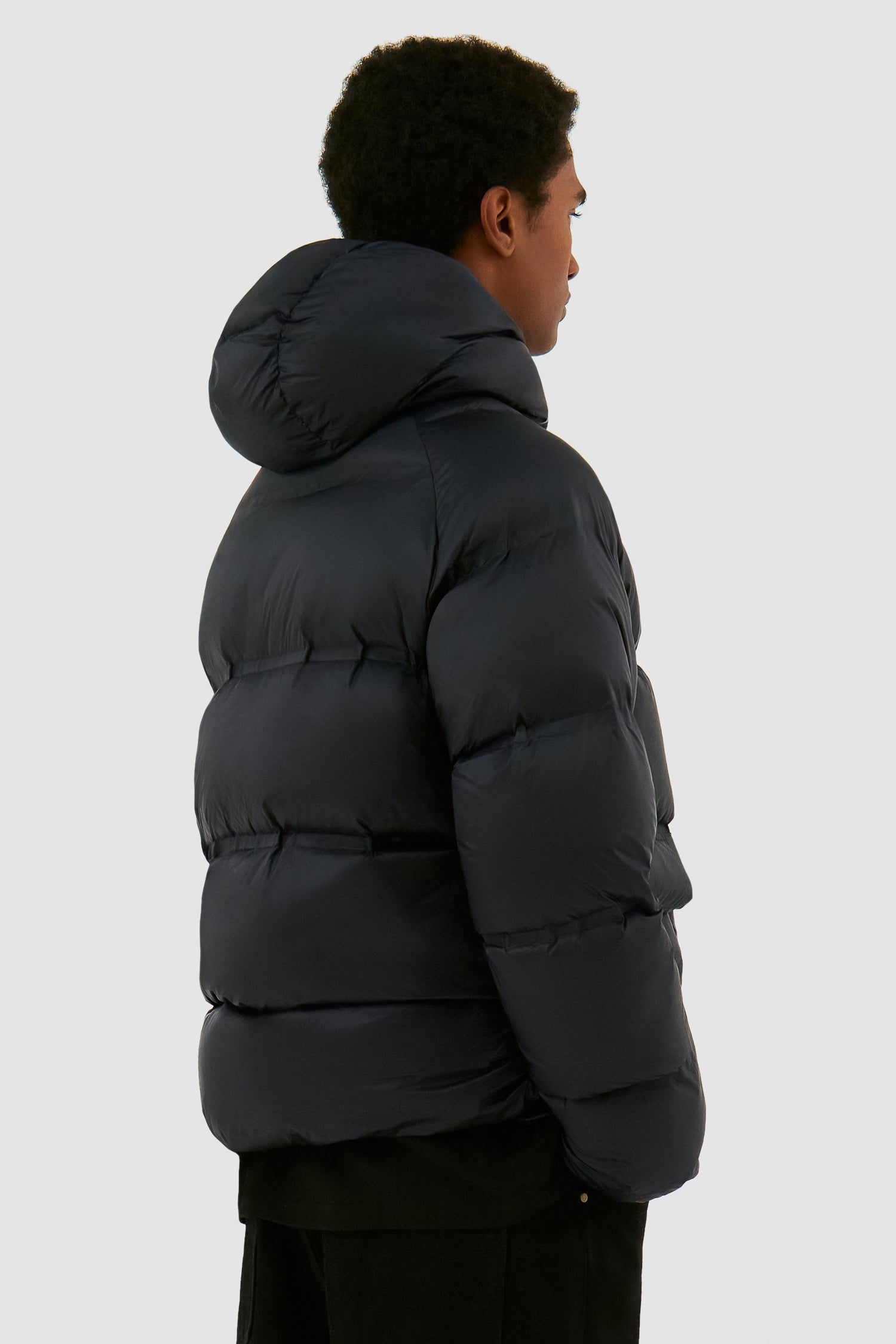 Crop Puffer Jacket in Black worn by a model, half-body back view