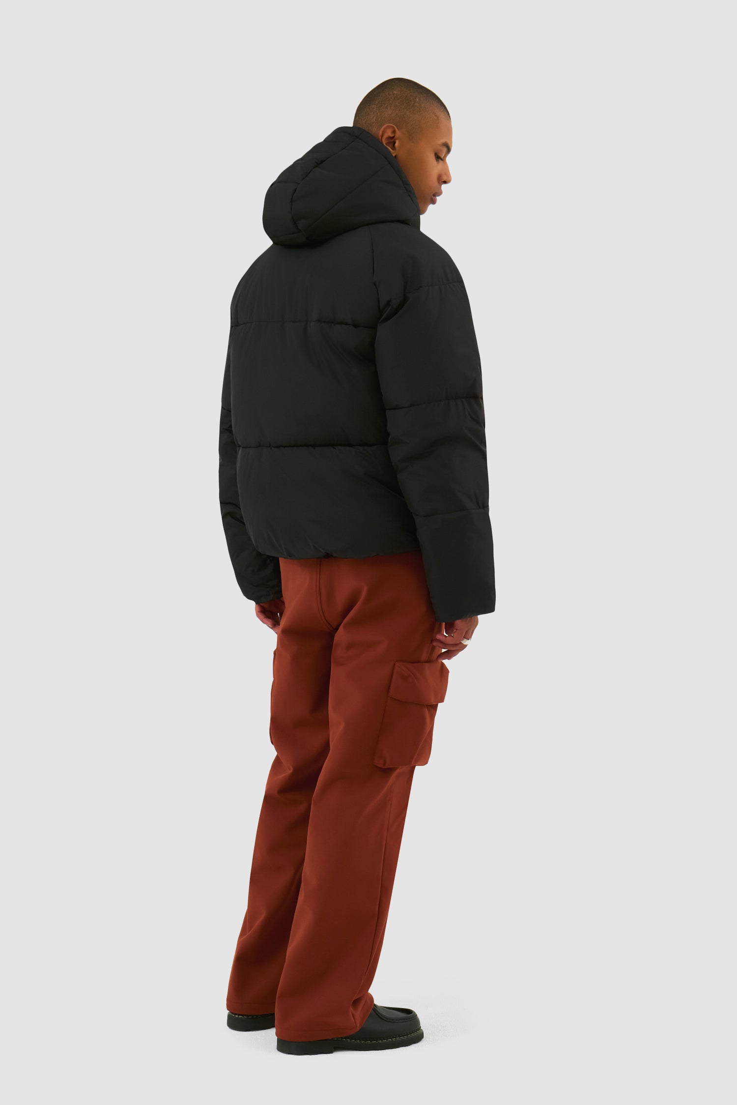 Puffer Jacket in Black worn by a model, full-body back view