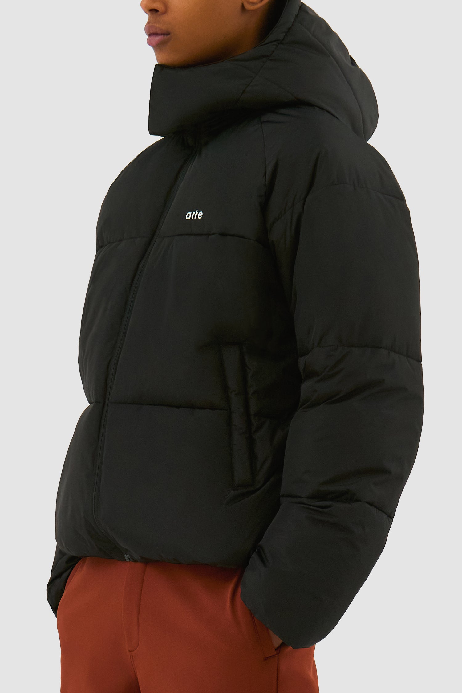 Puffer Jacket in Black worn by a model, half-body detailed view