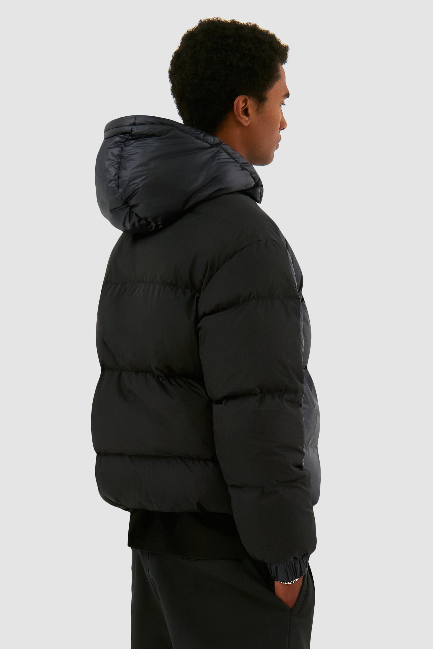 Shiny Puffer Jacket in Black worn by a model, half-body back view