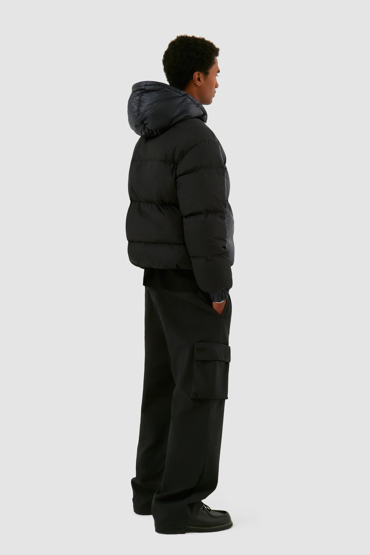 Shiny Puffer Jacket in Black worn by a model, full-body back view