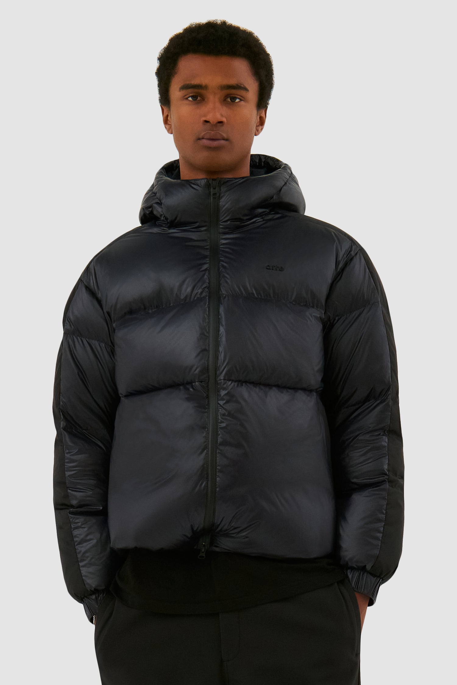Shiny Puffer Jacket in Black worn by a model, half-body front view