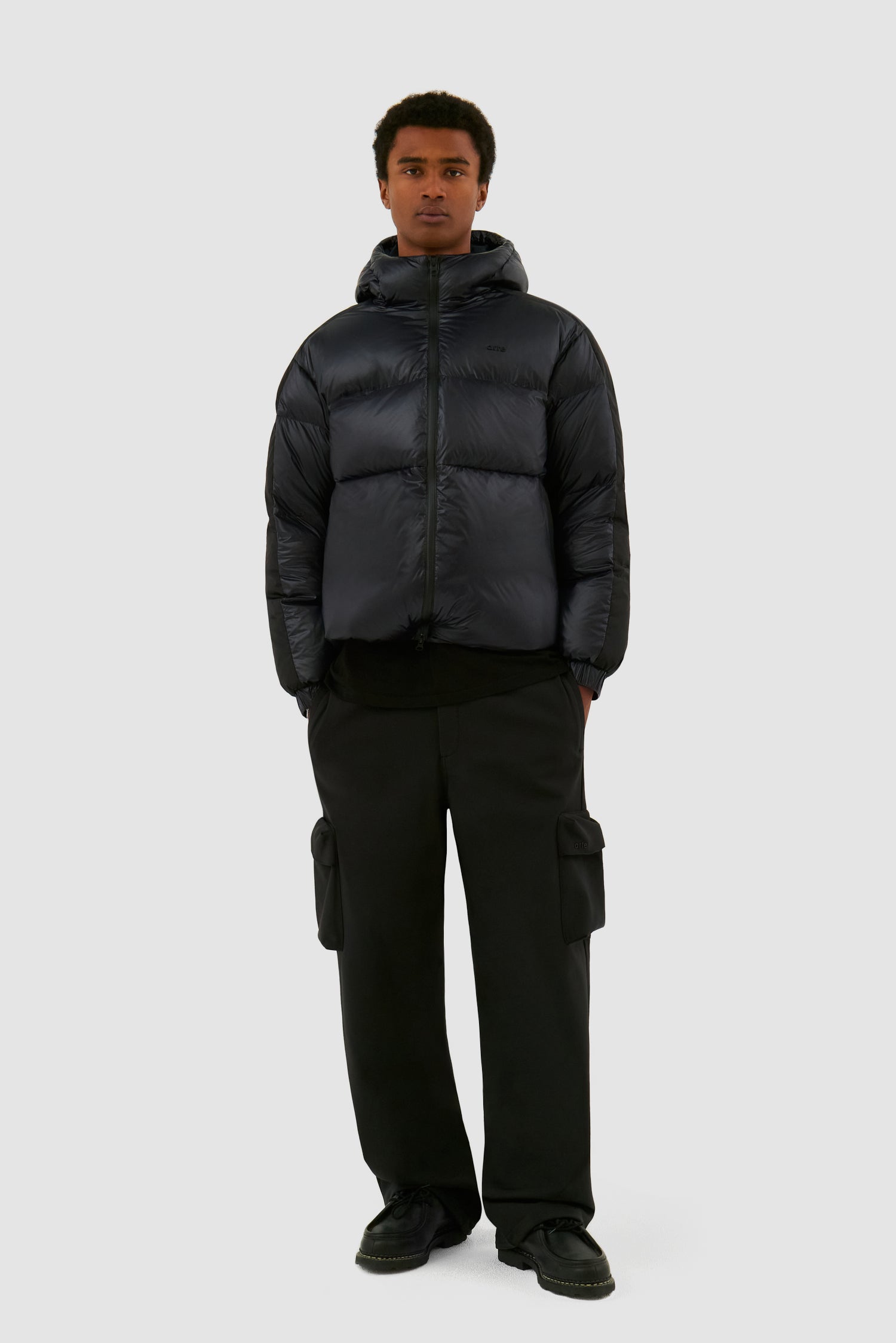 Shiny Puffer Jacket in Black worn by a model, full-body front view