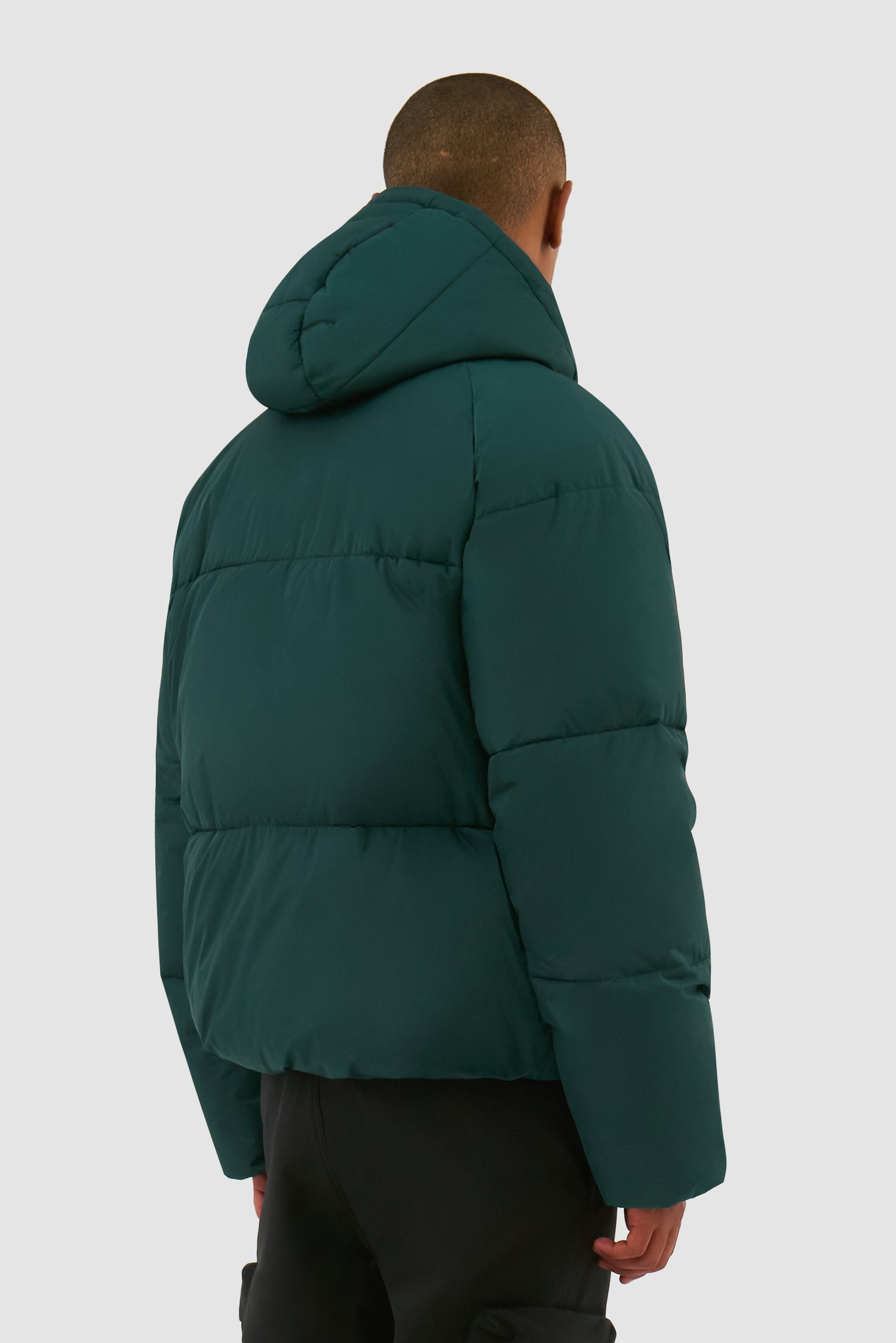 Puffer Jacket in Green worn by a model, half-body back view