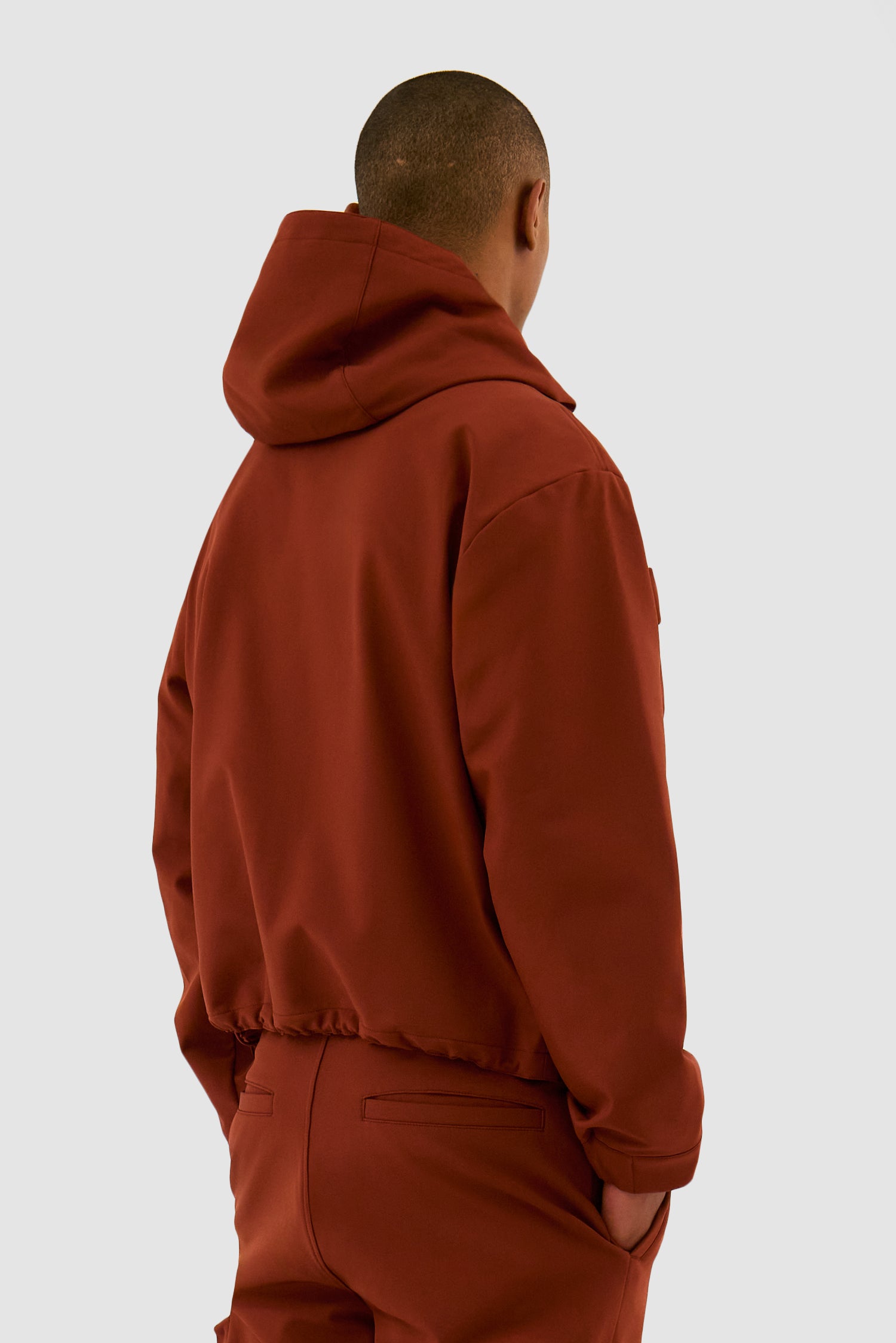 3D Pockets Hooded Nylon Jacket in Orange worn by a model, half-body back view