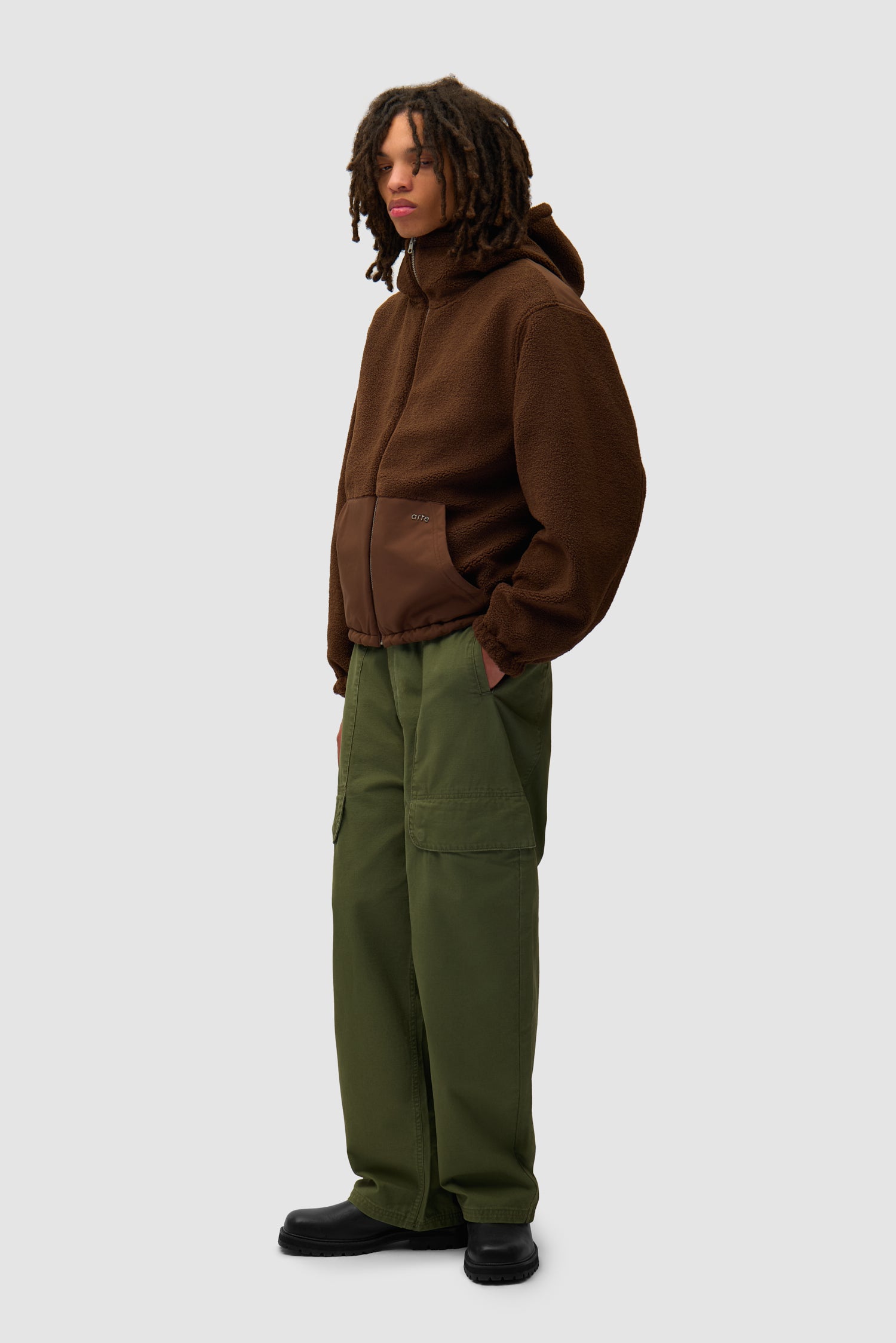 Veste technique en nylon de couleur marron portée par un mannequin, vue latérale du corps entier