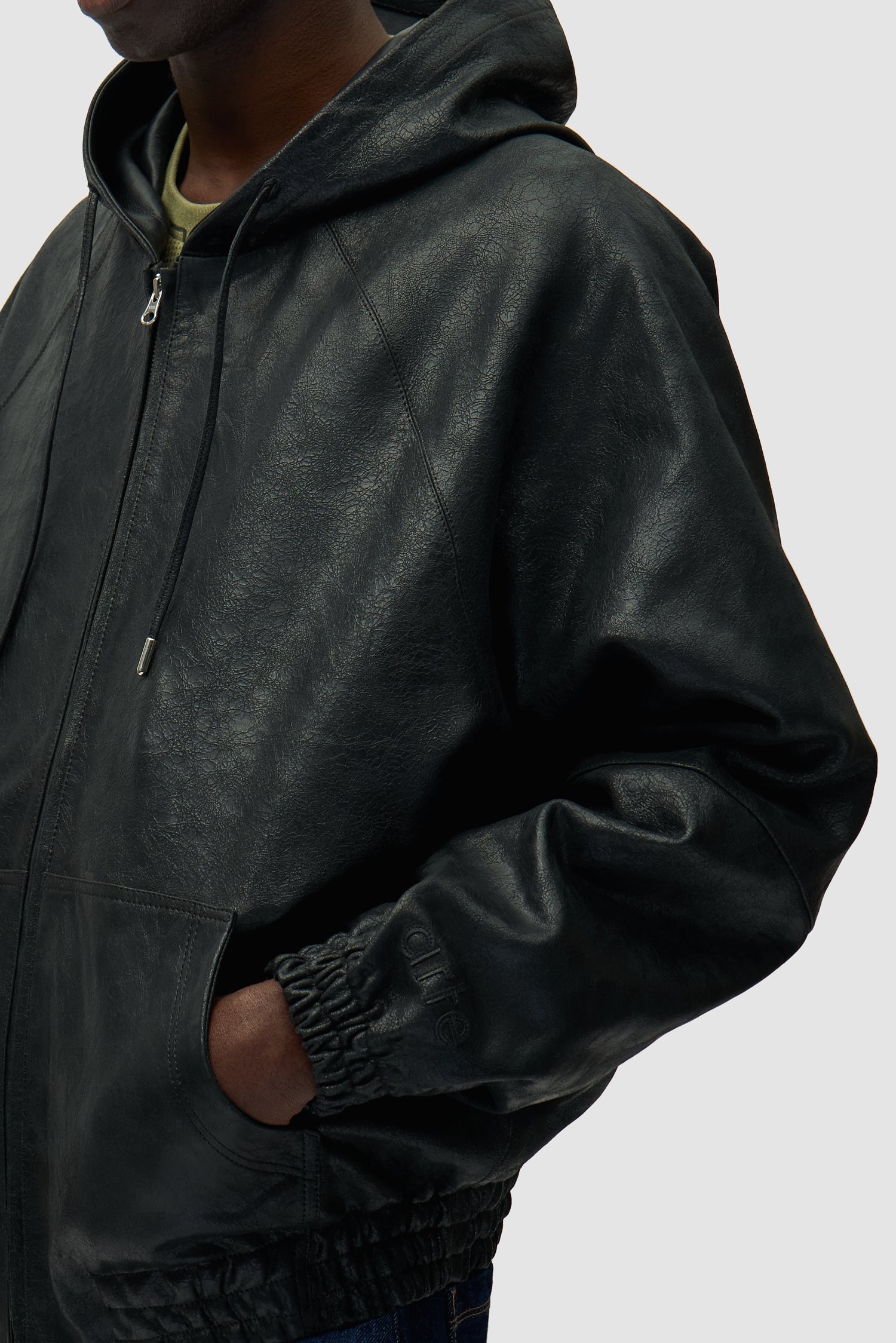 Veste en cuir craquelé noire portée par un mannequin, vue de profil à mi-corps