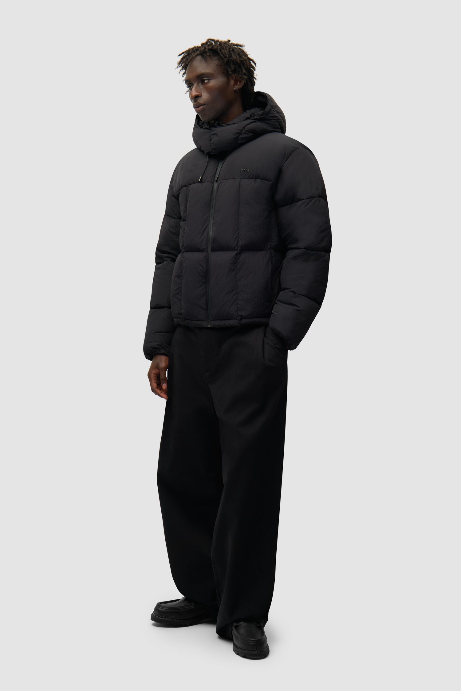 Special Cuts Puffer Jacket in Black portée par un mannequin, vue latérale sur l'ensemble du corps