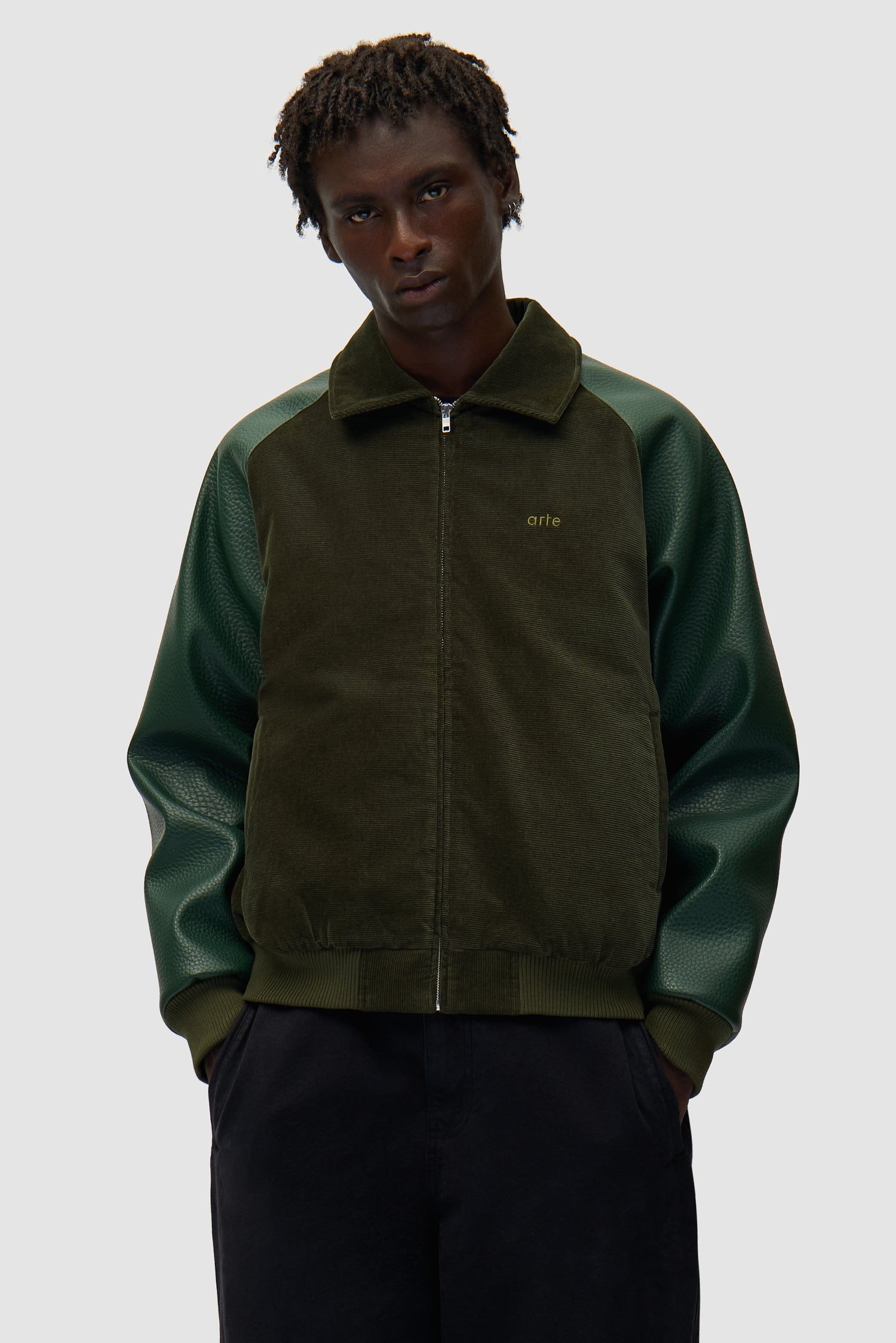 Veste universitaire en vert portée par un mannequin, vue de face à mi-corps