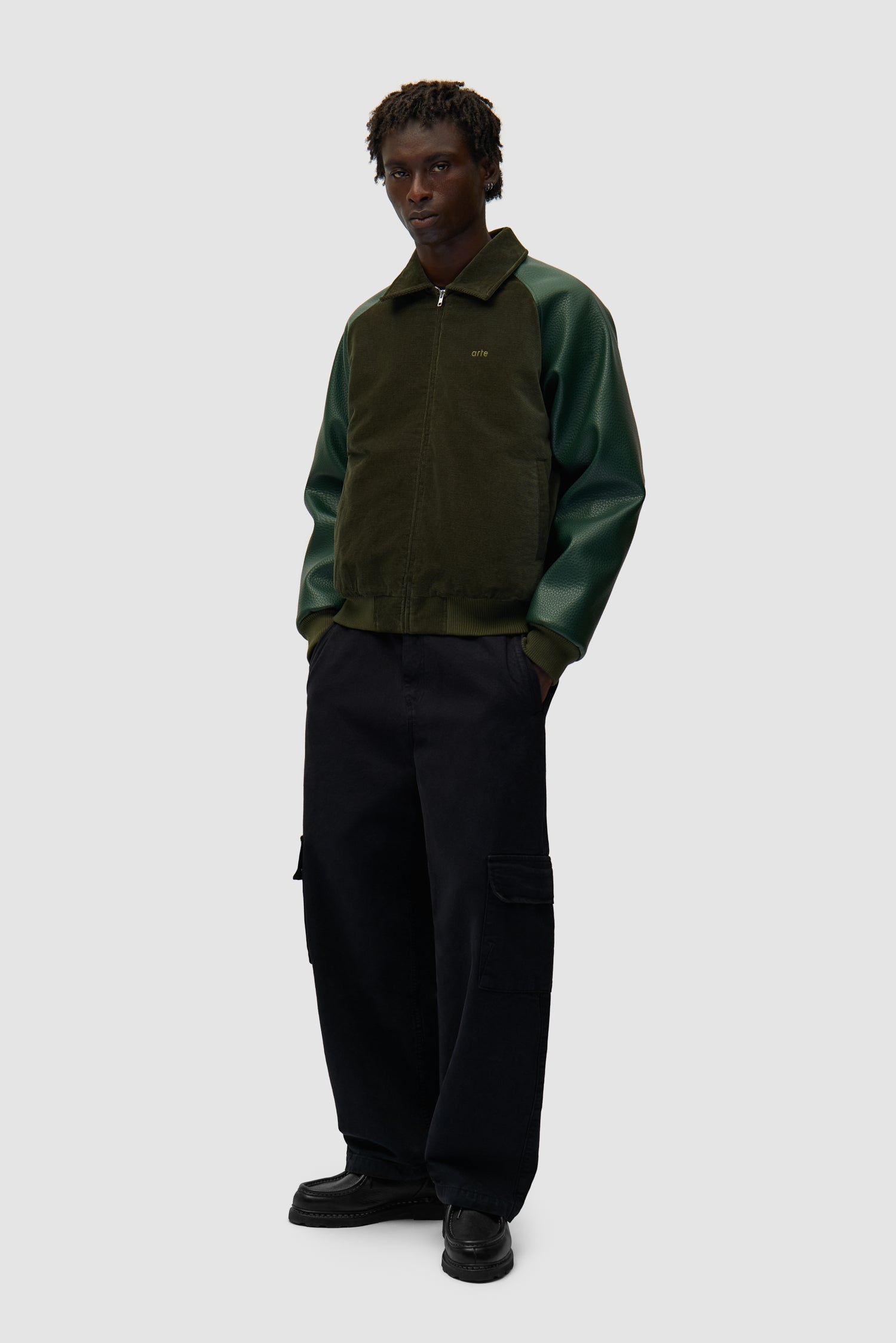 Veste Varsity en vert portée par un mannequin, vue latérale sur l'ensemble du corps