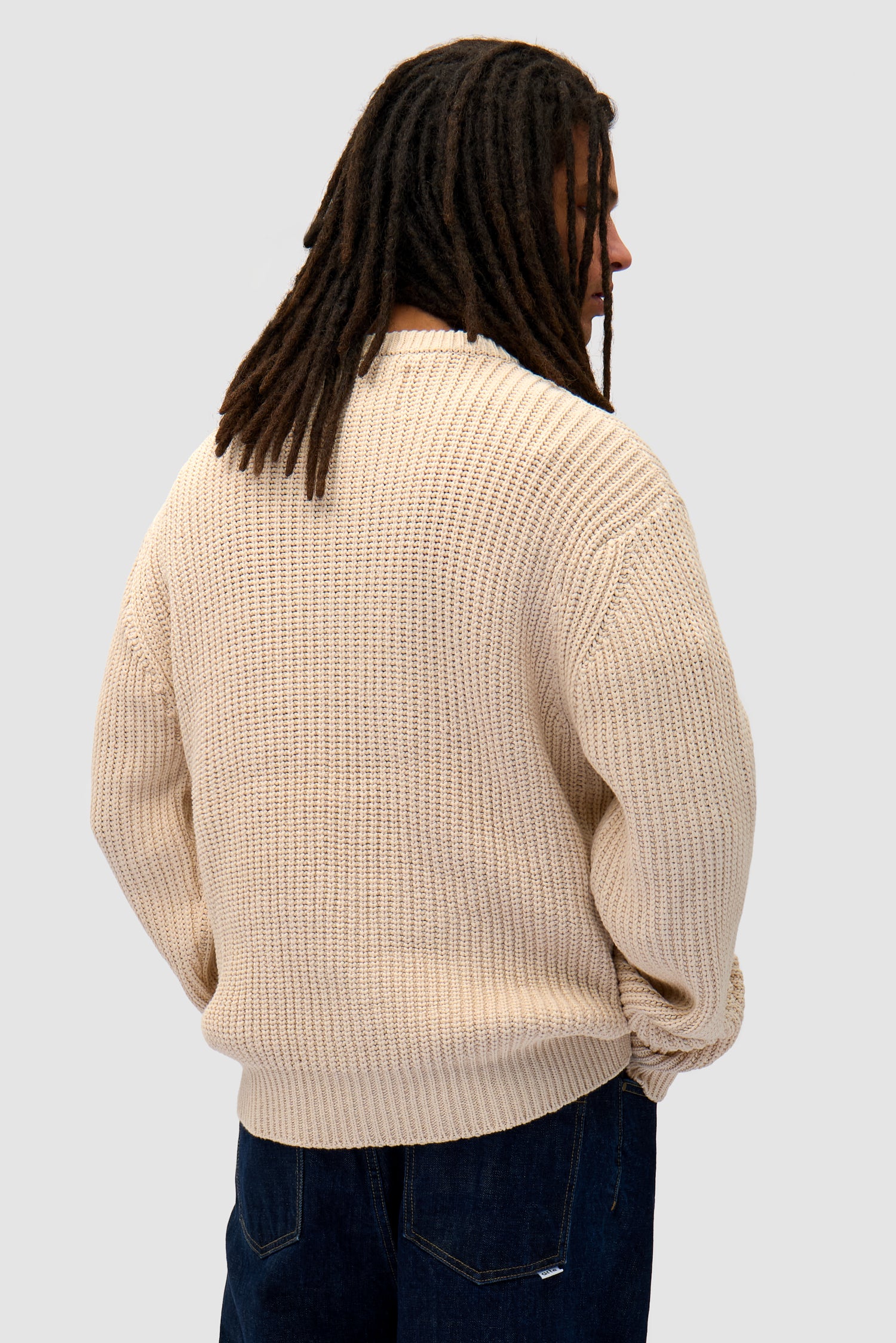 Cross Stitch Knit in Cream worn by a model, half-body back view