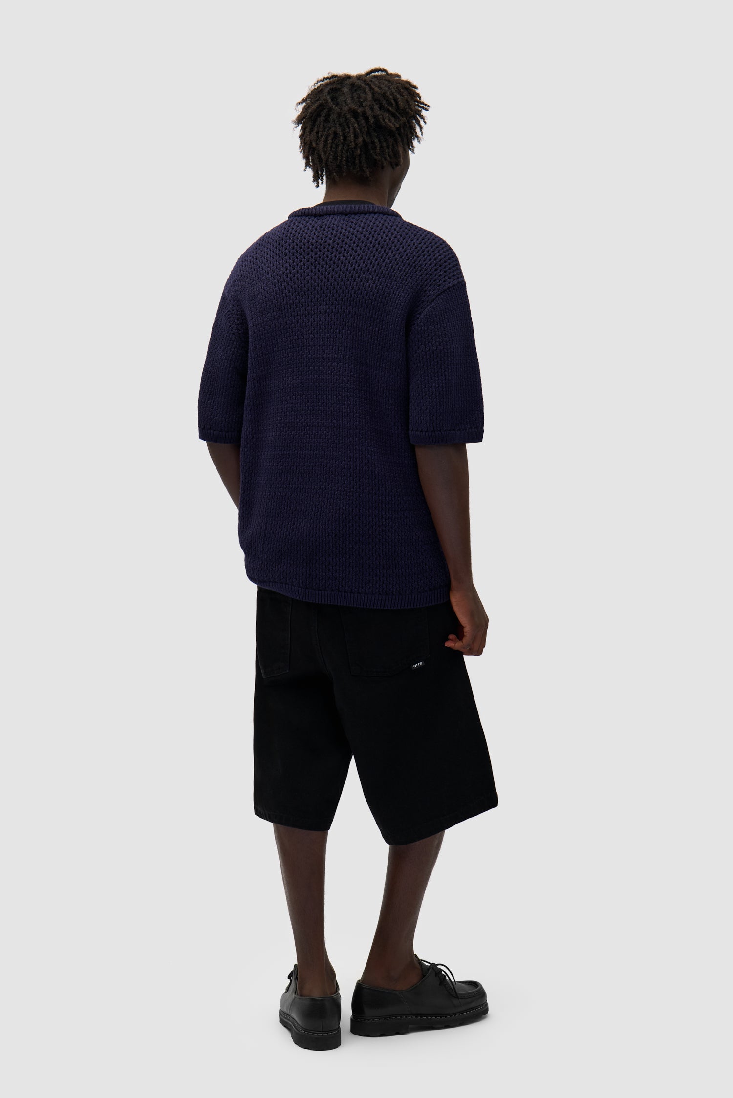 Crochet Knit T-shirt in Navy worn by a model, full-body back view