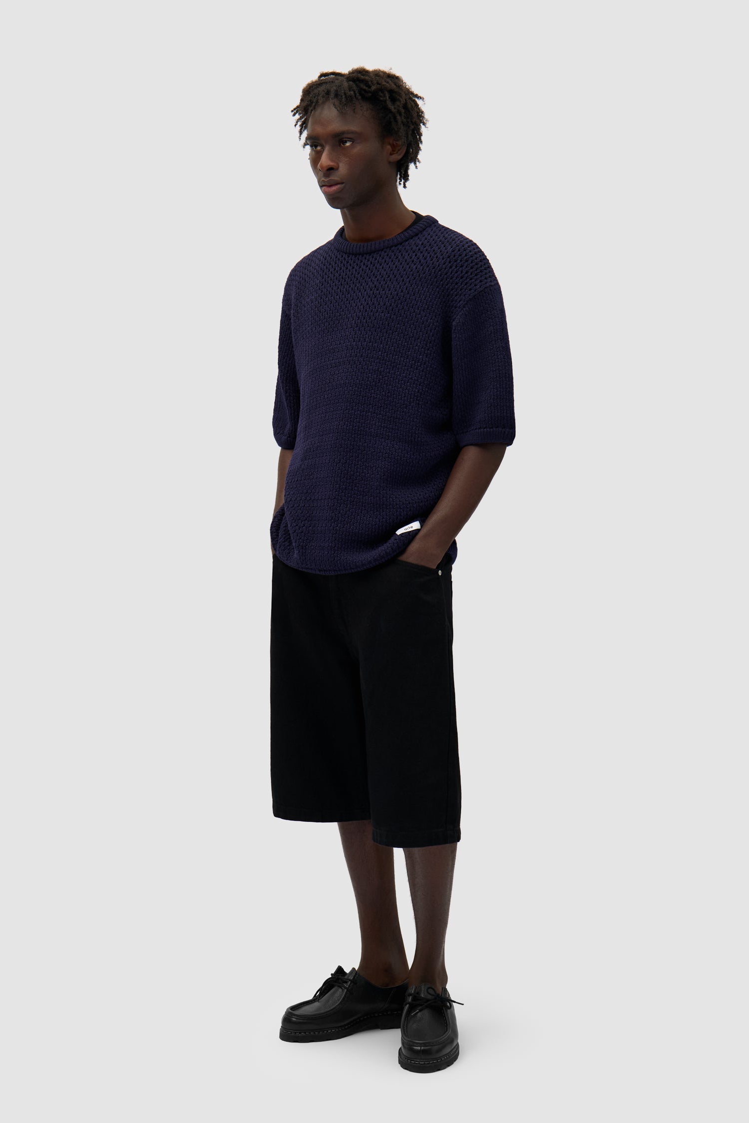 Crochet Knit T-shirt in Navy worn by a model, full-body side view