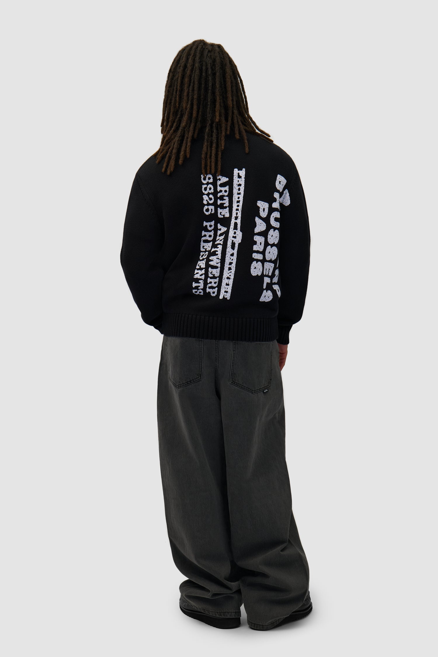 Big Print Knit Sweater in Black worn by a model, full-body back view