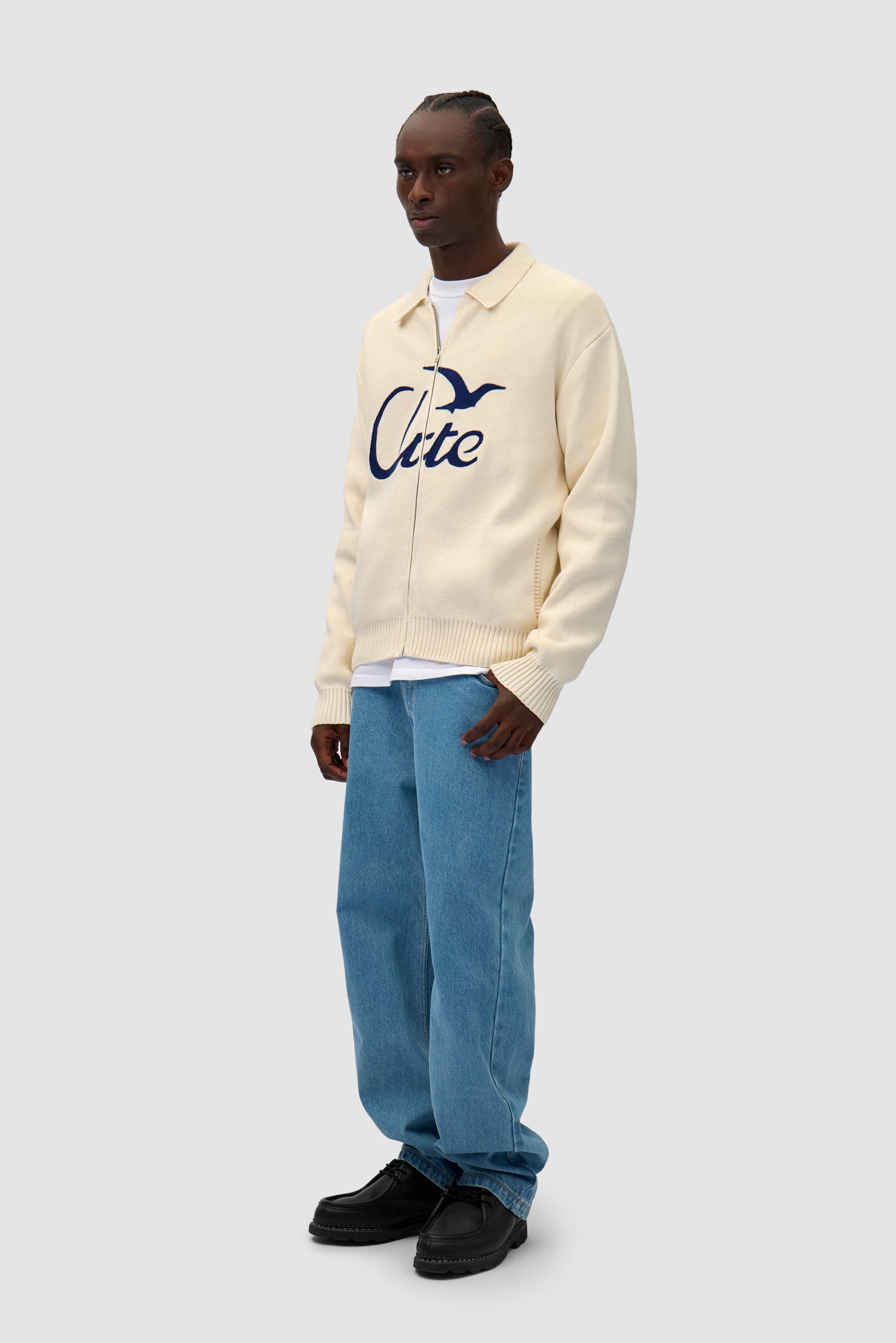 Bird Logo Knit in Cream worn by a model, full-body side view