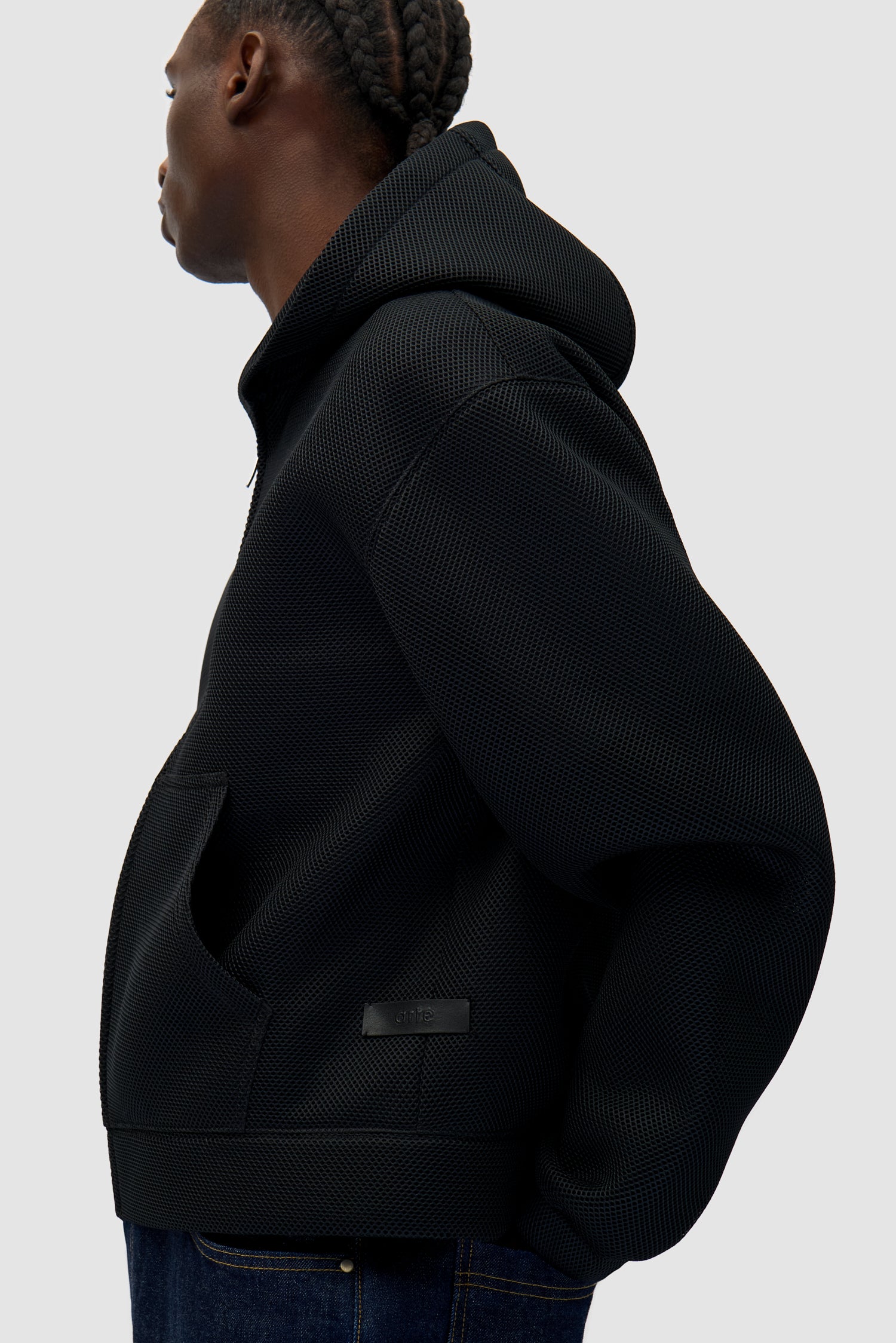 Mesh Hooded Jacket in Black worn by a model, half-body side view