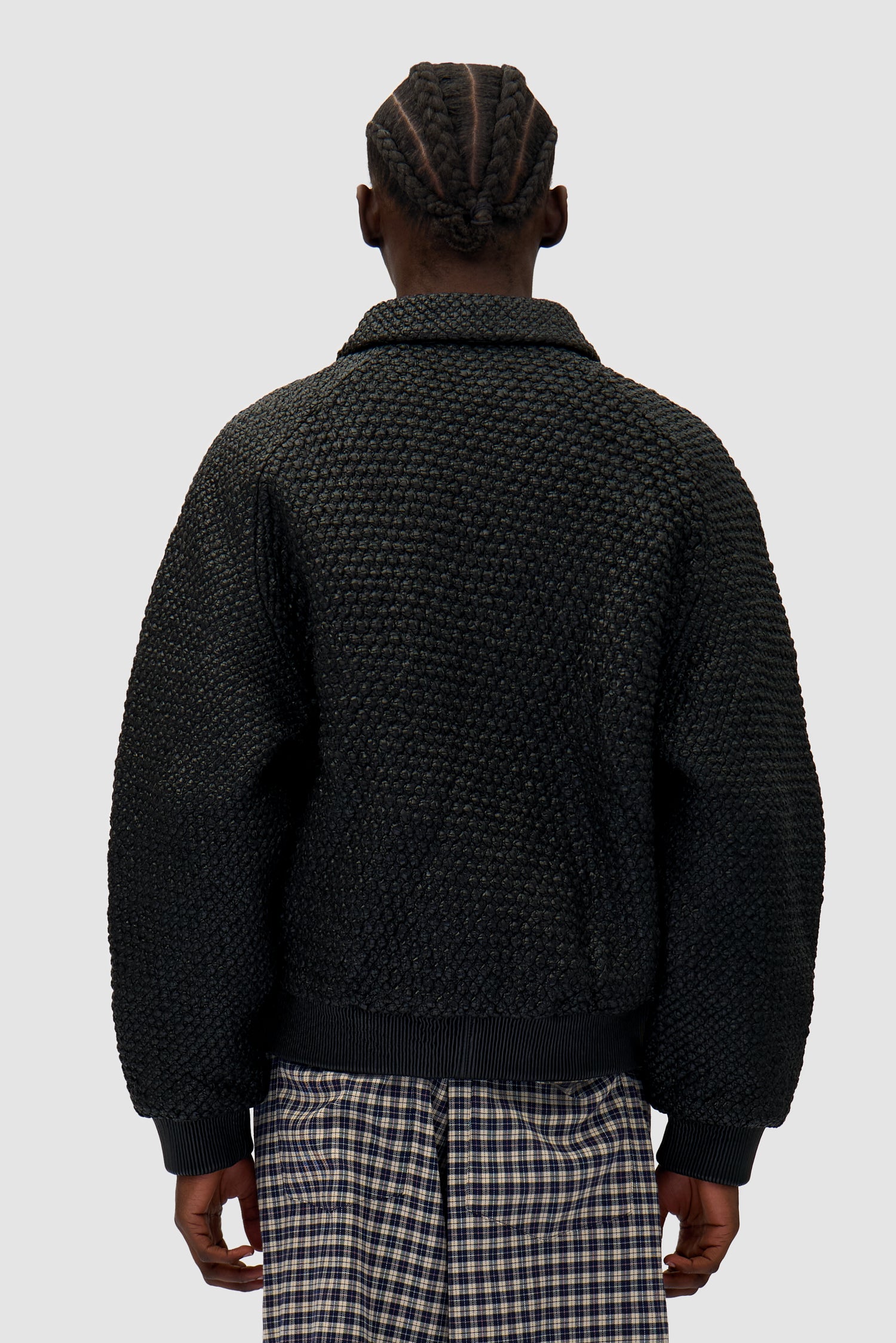 Leather Braided Jacket in Black worn by a model, half-body back view