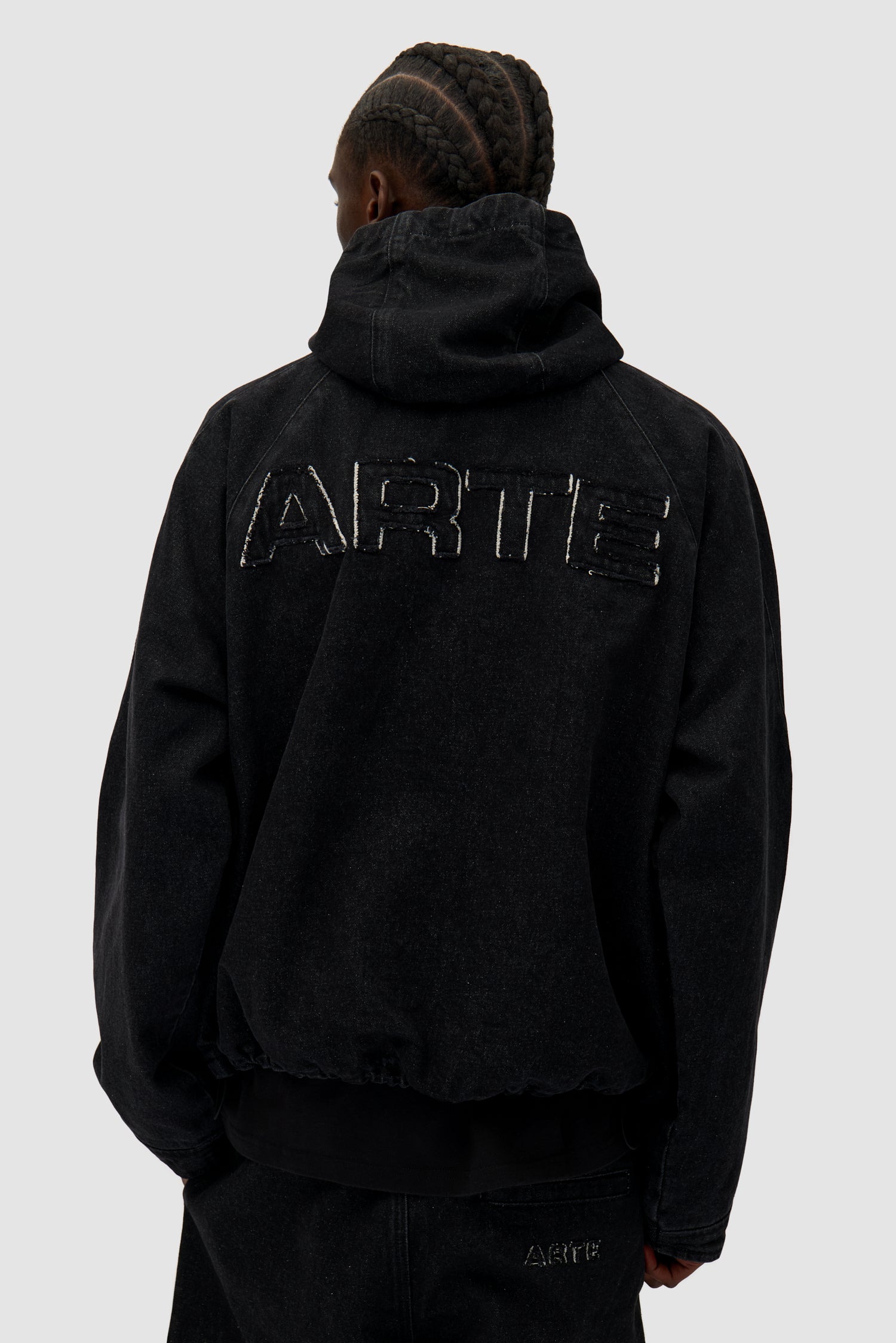 Denim Tech jacket in Black worn by a model, half-body back view