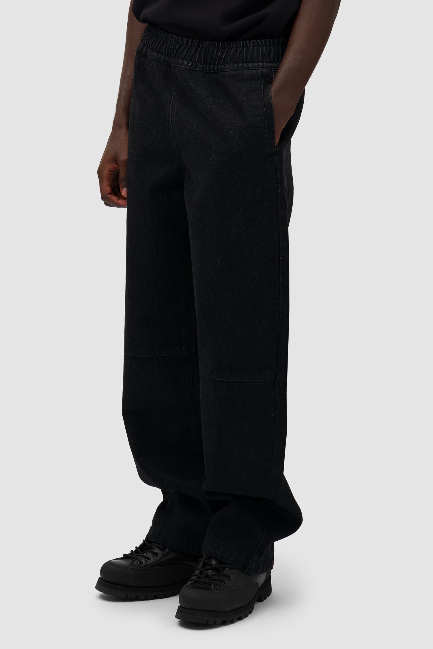 Denim Tech Pants in Black worn by a model, half-body side view